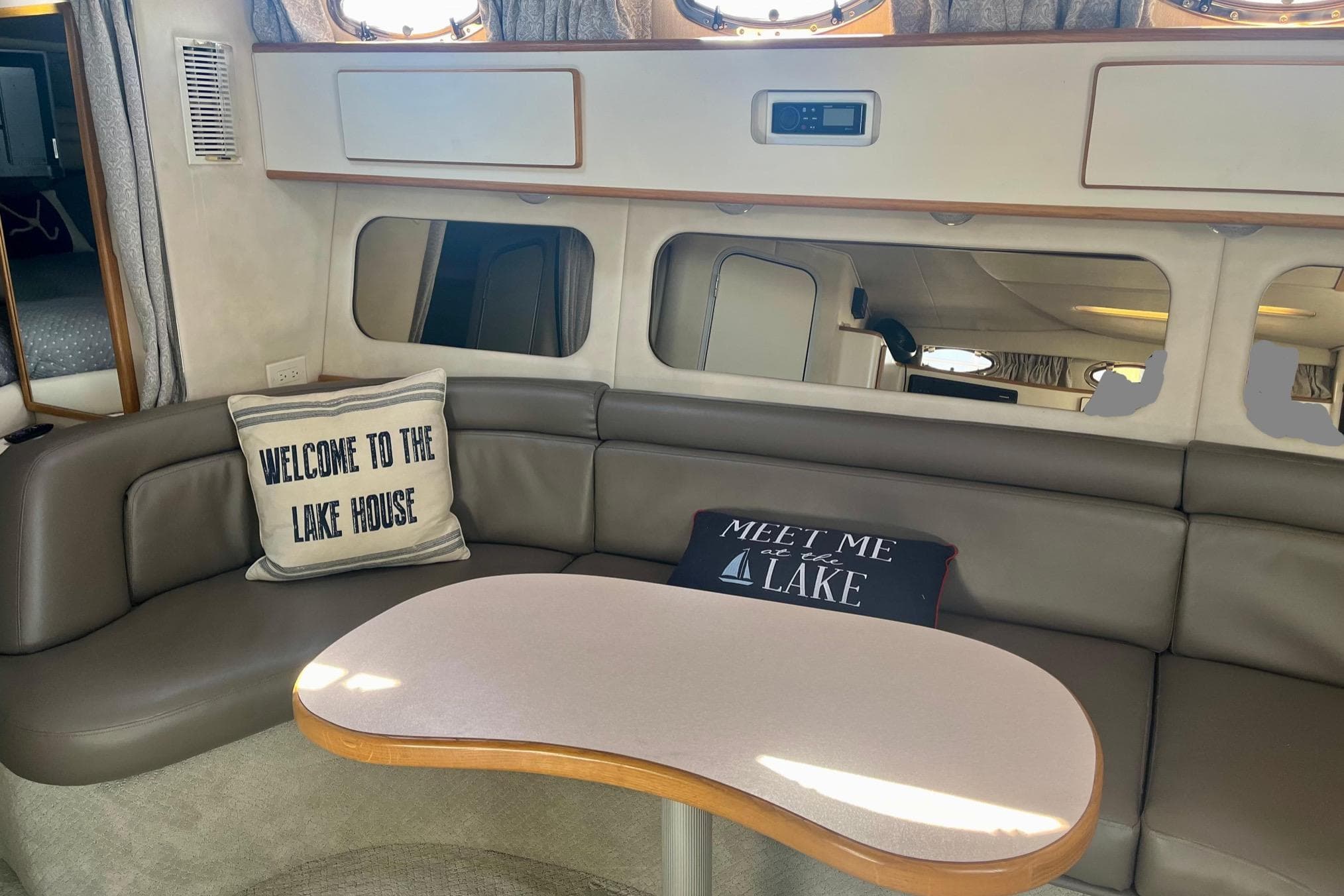 Interior of 1994 Sea Ray 370 Express Cruiser with cozy seating and decorative pillows.
