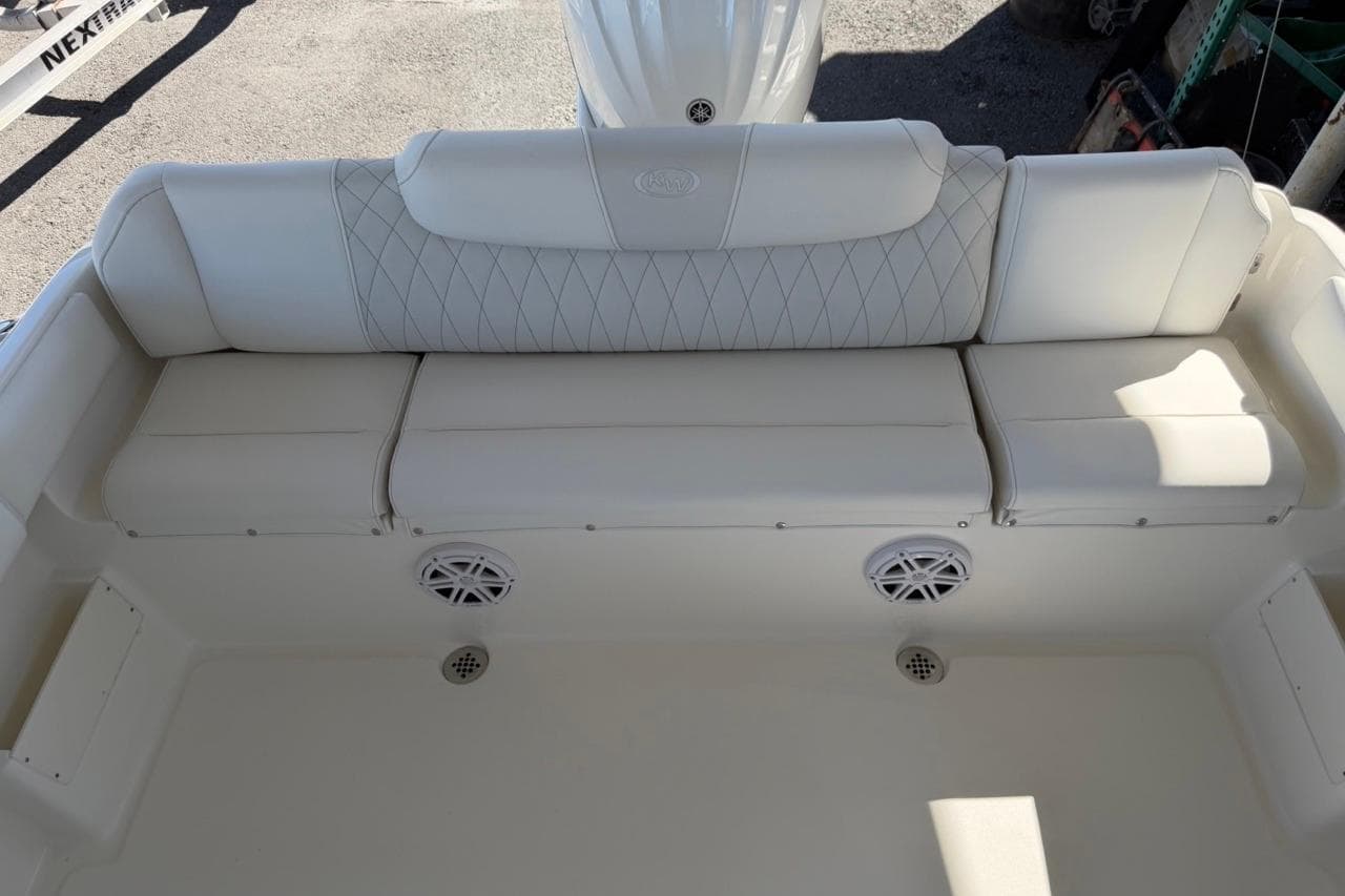 2026 Key West 239 FSR boat interior with white cushioned seating and built-in speakers.