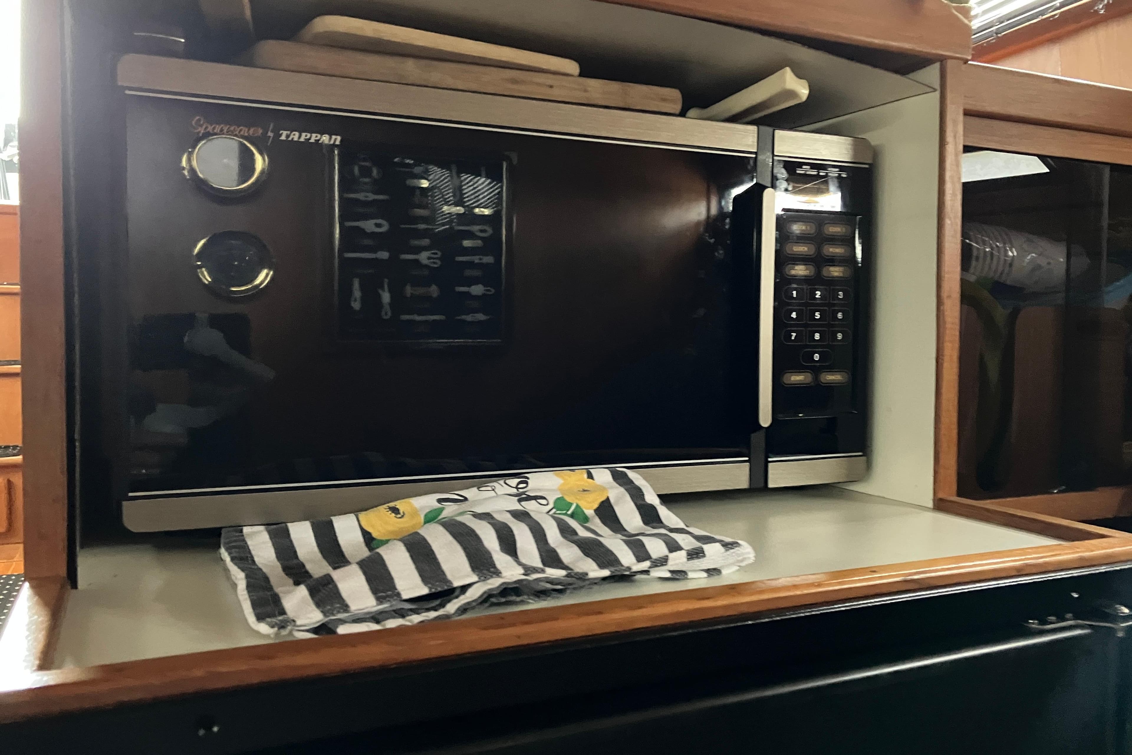 Microwave in 1987 President 37 Sundeck yacht kitchen with striped towel.