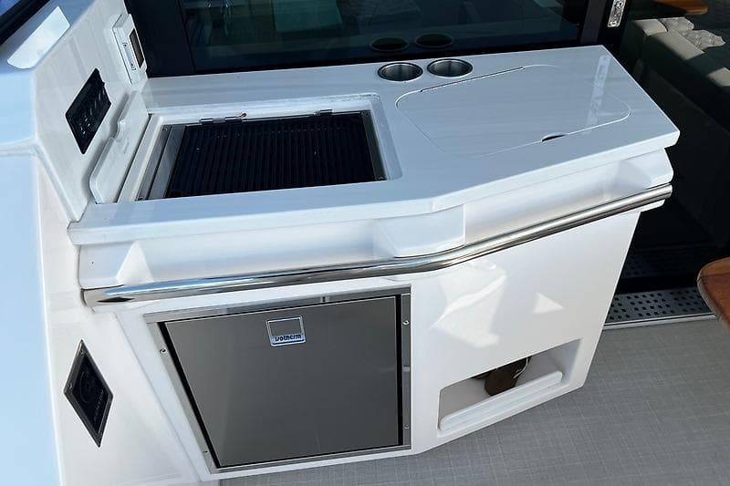 Outdoor kitchen on 2024 Regal 38 Grande Coupe yacht with grill and storage.