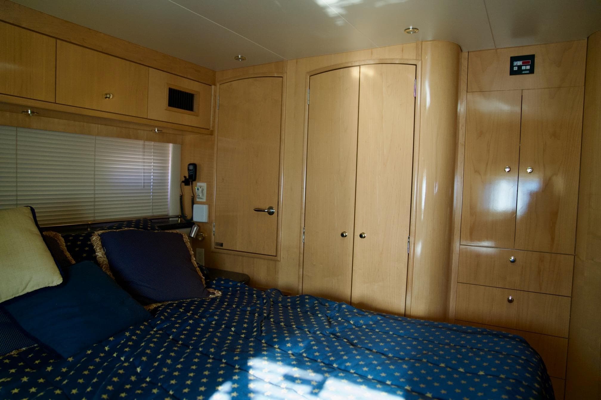 Luxurious bedroom interior of 2000 Carver 506 Motor Yacht with wood cabinetry and cozy bedding.