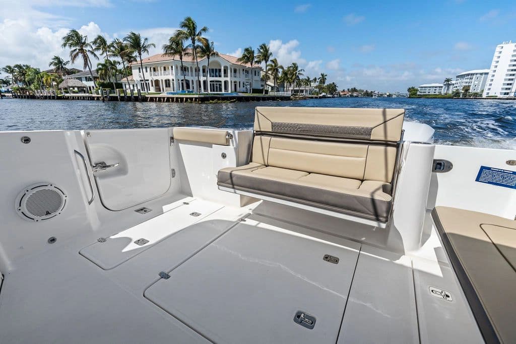 Luxurious interior of 2019 Pursuit 365 DC yacht with waterfront view and palm trees.