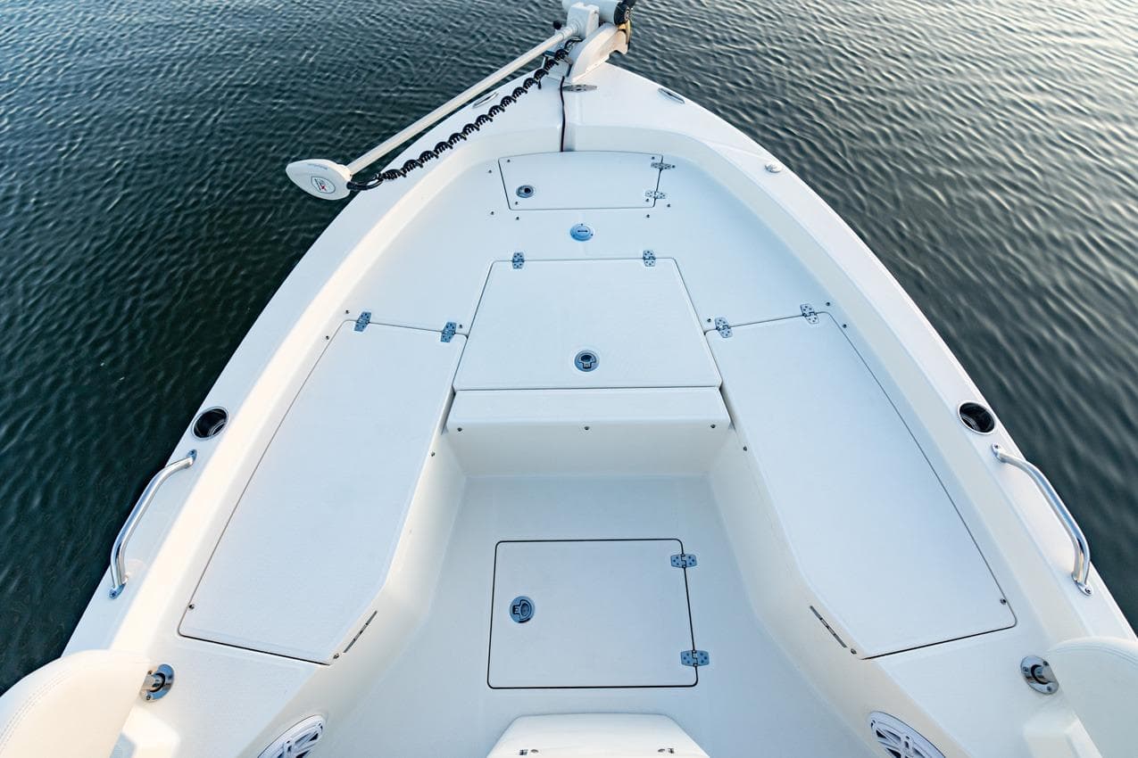 2026 Pathfinder 2200 TRS boat deck, featuring storage compartments and sleek design on calm water.