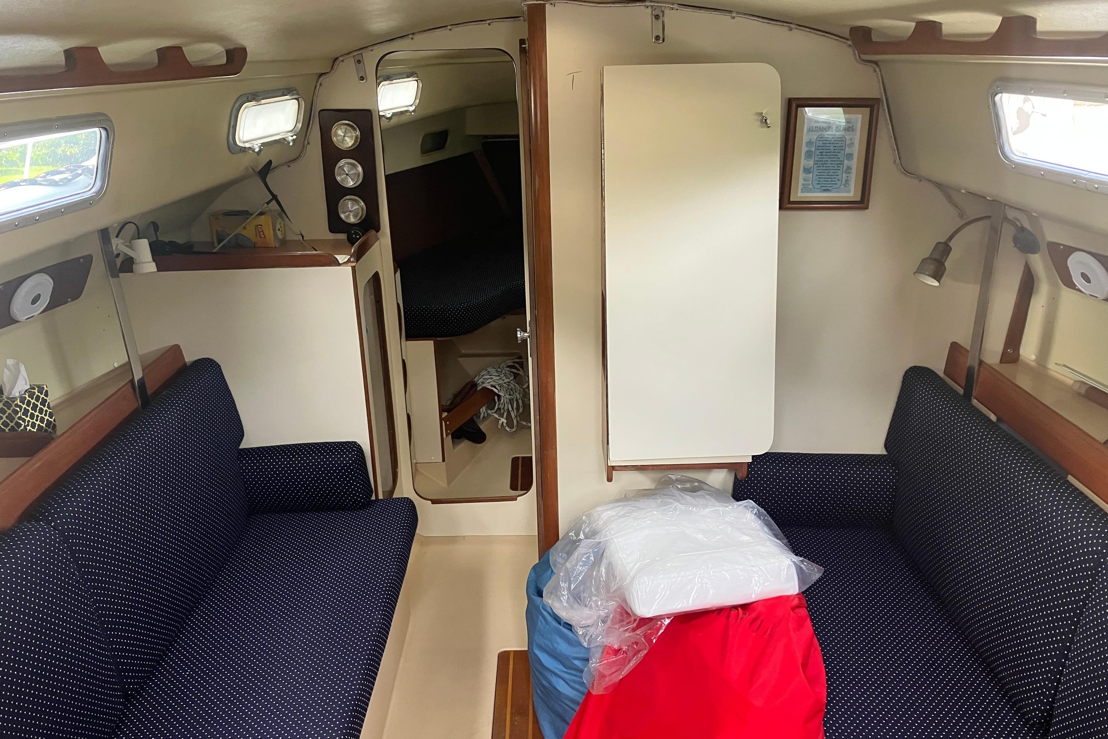 Interior of 1983 Pearson 303 Sloop sailboat with cozy seating and nautical decor.