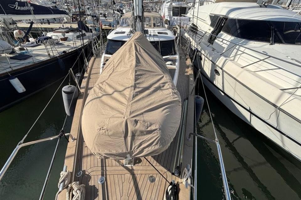 2021 Discovery 58 yacht with covered deck, docked among other boats in a marina.