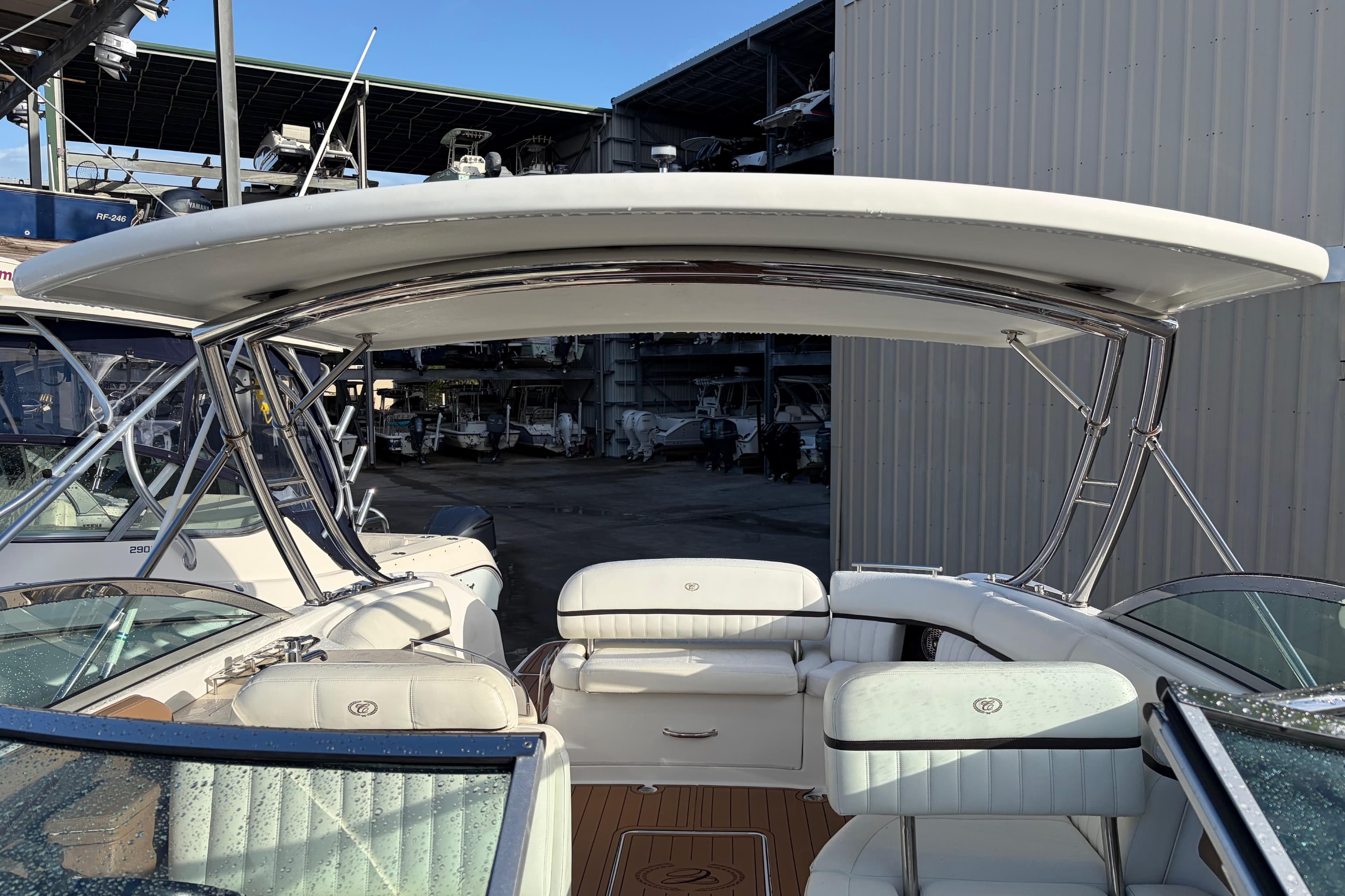 2015 Cobalt 336 boat interior with white seating and sleek design in a marina setting.