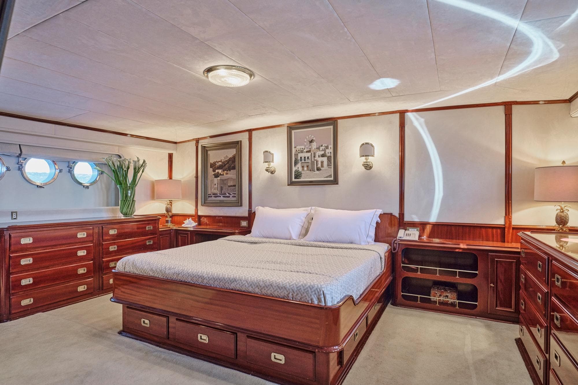 Luxurious 1975 CRN 40 yacht bedroom with elegant wood furnishings and nautical decor.