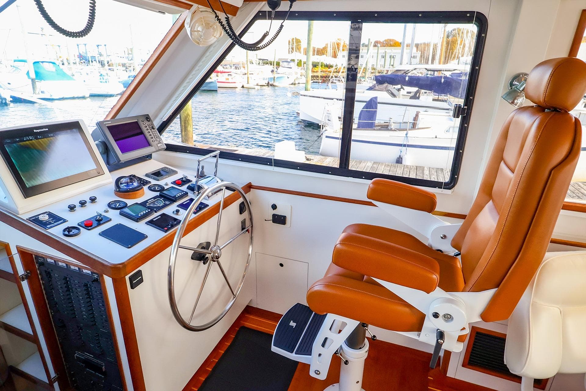 Helm of 2005 New England Boatworks Downeast Sedan with leather captain's chair and navigation equipment.