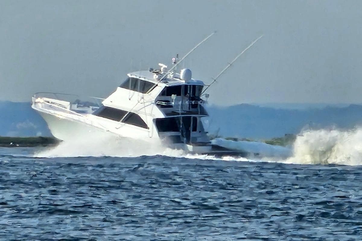 2002 Viking 61 Enclosed Bridge yacht cruising through waves on open water.