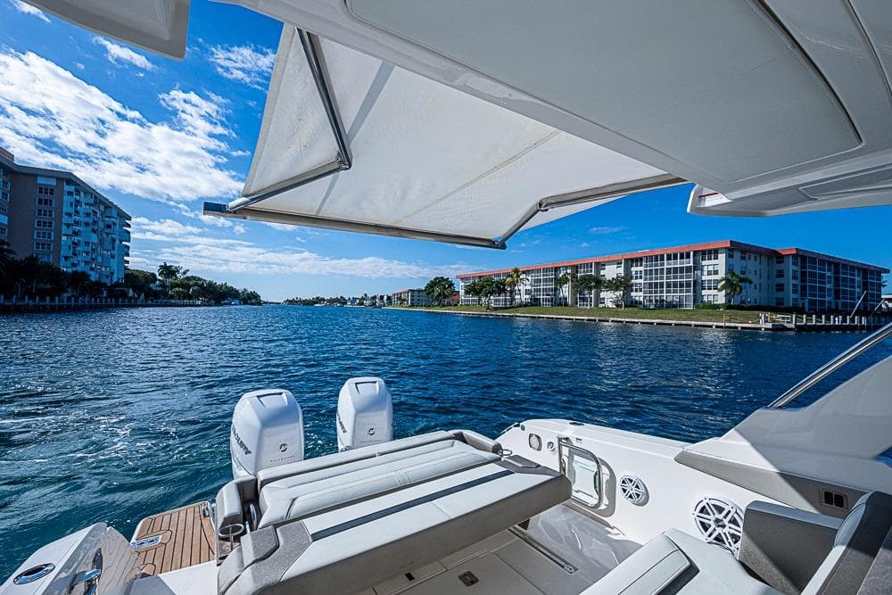 2023 Tiara Yachts 34 LS on water, featuring luxury seating and scenic waterfront view.