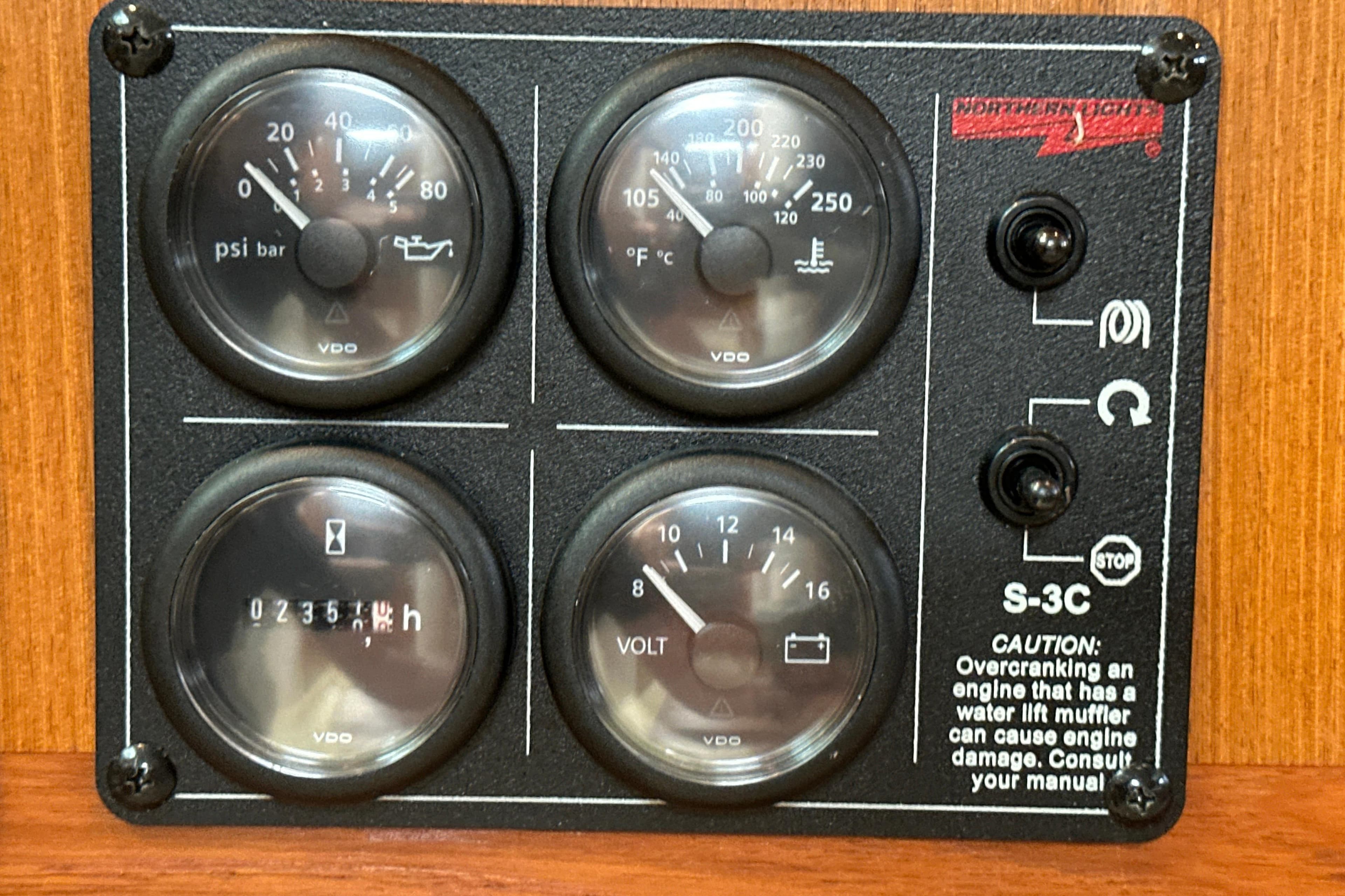 Instrument panel of a 2000 Cabo 45 Express boat with gauges and caution label.