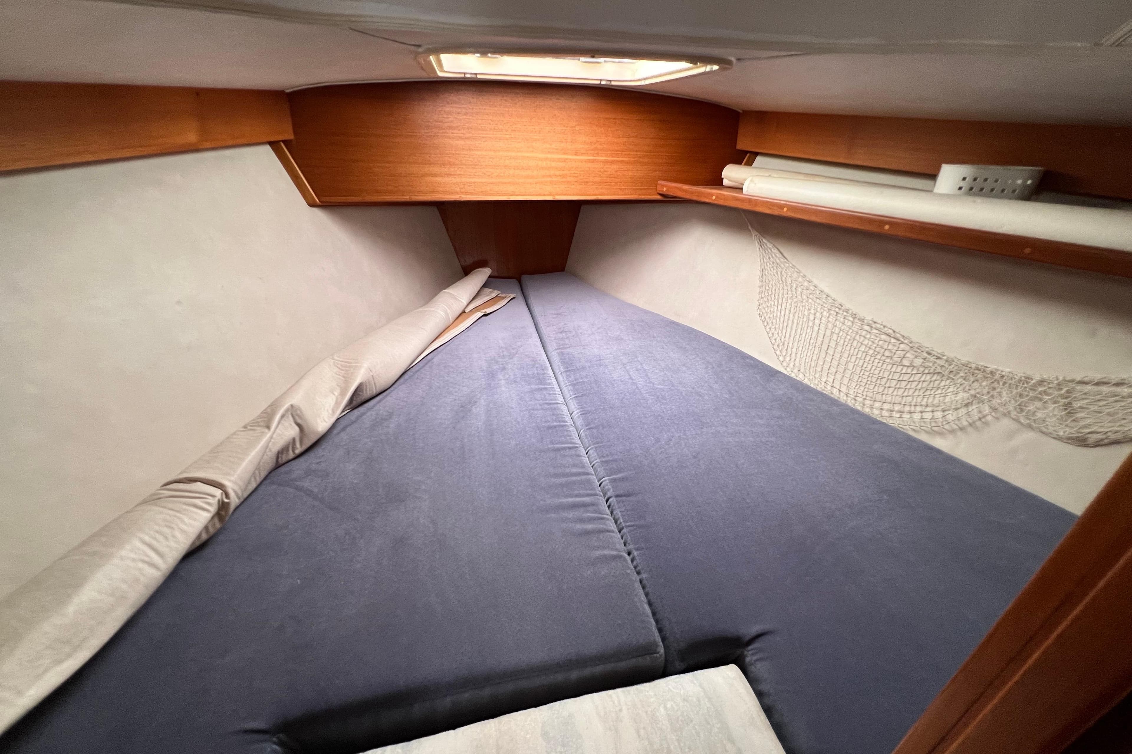 Cozy cabin interior of 1996 Caliber 35 LRC sailboat with blue bedding.