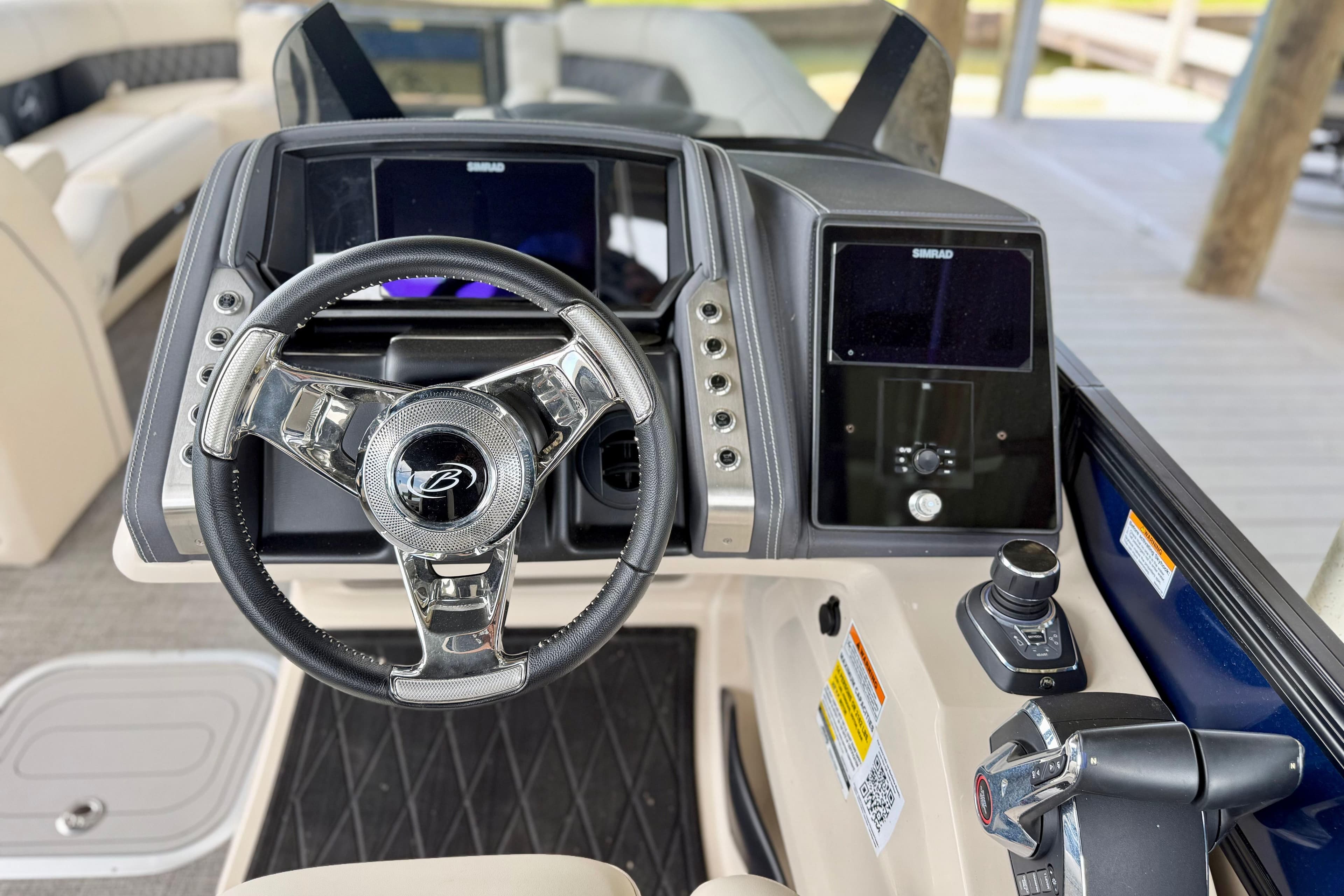 2025 Barletta L25UCAT boat dashboard with steering wheel and control panel.