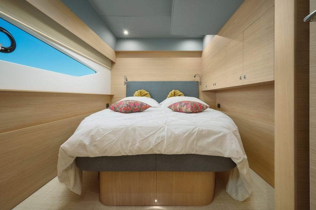 Luxurious bedroom interior of 2024 Aquila 54 Yacht with modern design and cozy bedding.