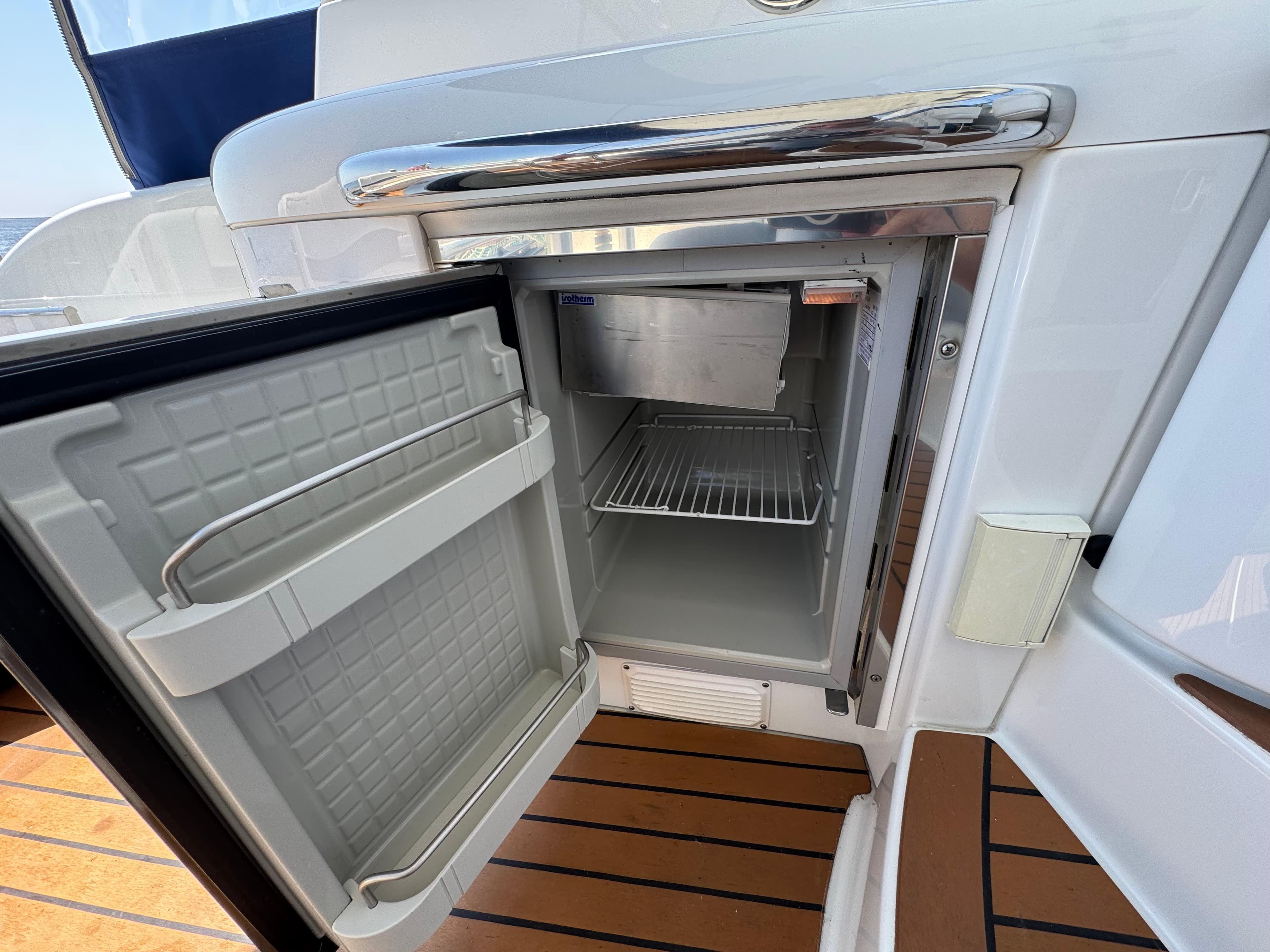 Open mini fridge on 2008 Formula 40 PC yacht, showcasing interior shelves and sleek design.