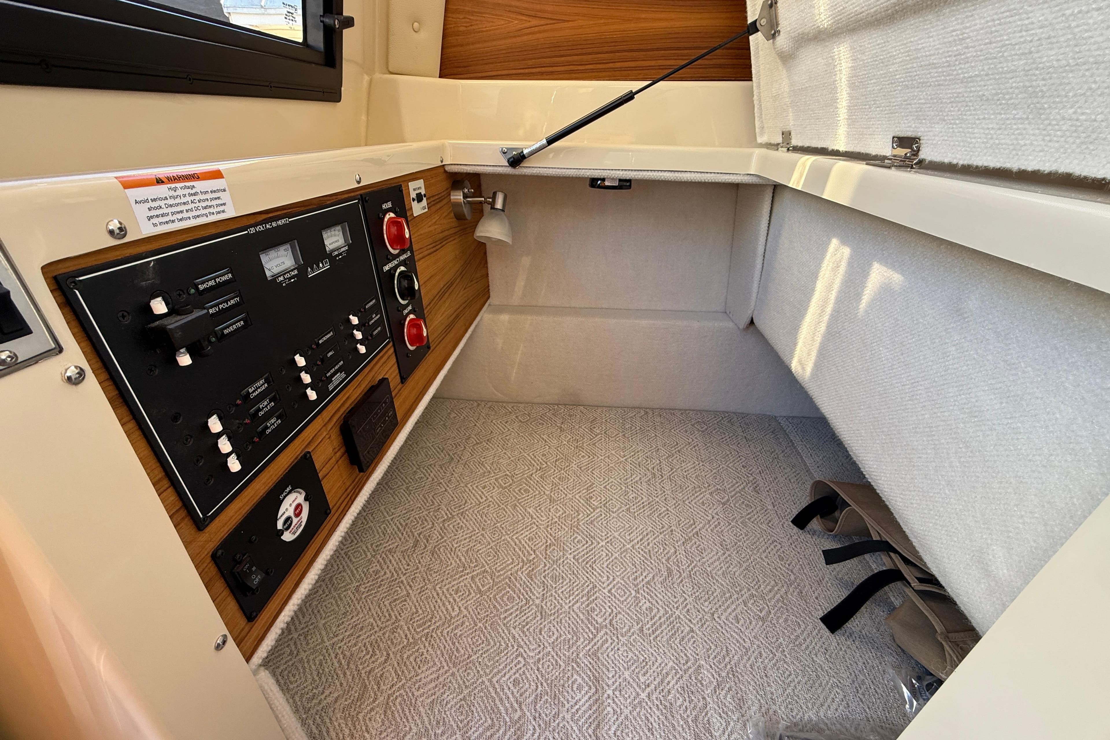 2026 Ranger Tugs R-23 interior cabin with control panel and storage space.