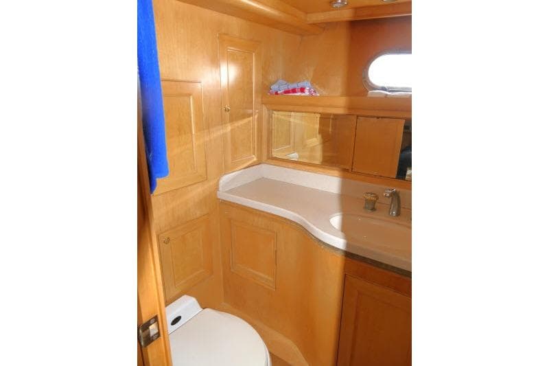 Bathroom interior of 1999 Hampton 490 Pilothouse yacht with wooden cabinetry and modern fixtures.