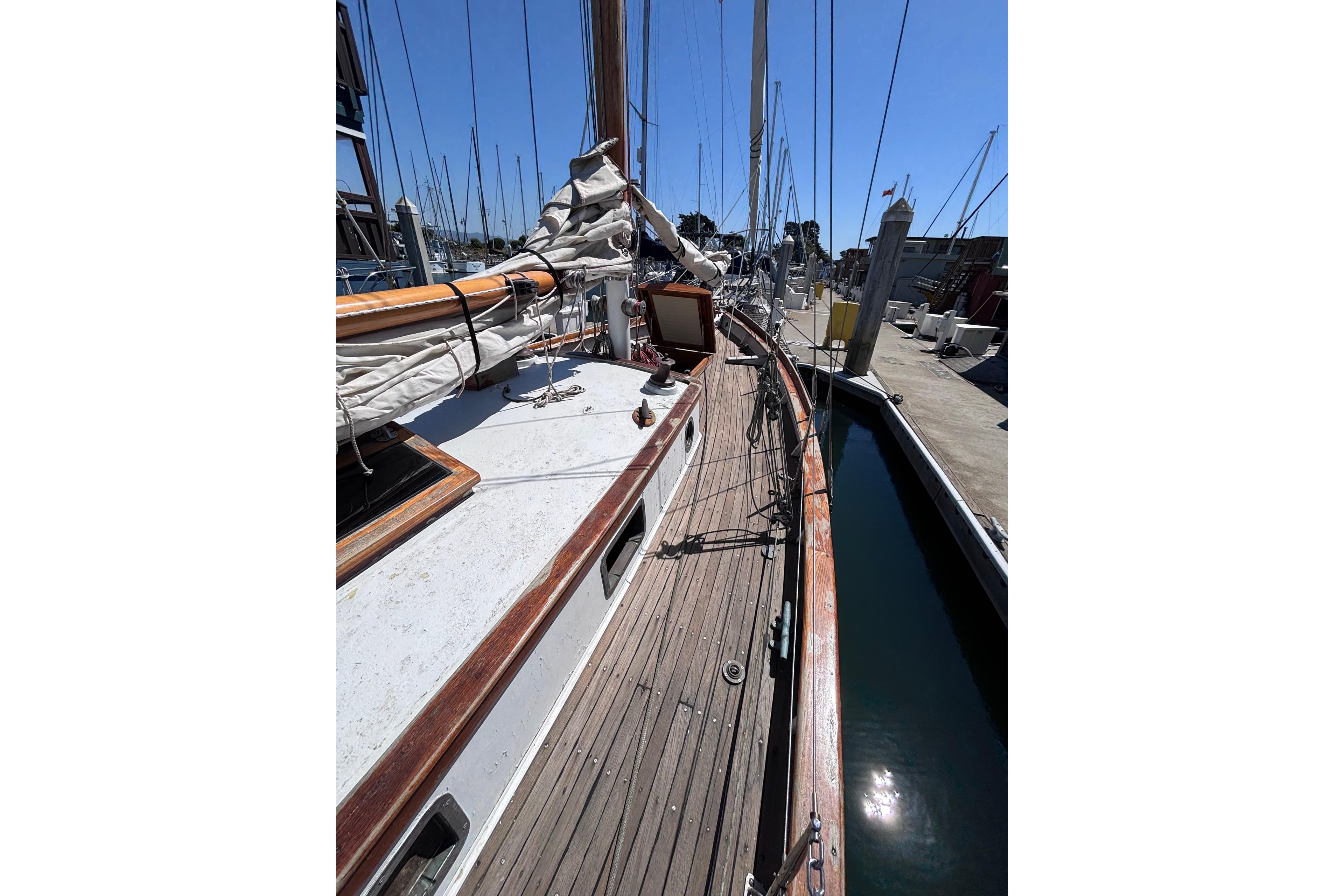 Vintage 1970 Chen sailboat docked at marina, showcasing wooden deck and rigging.