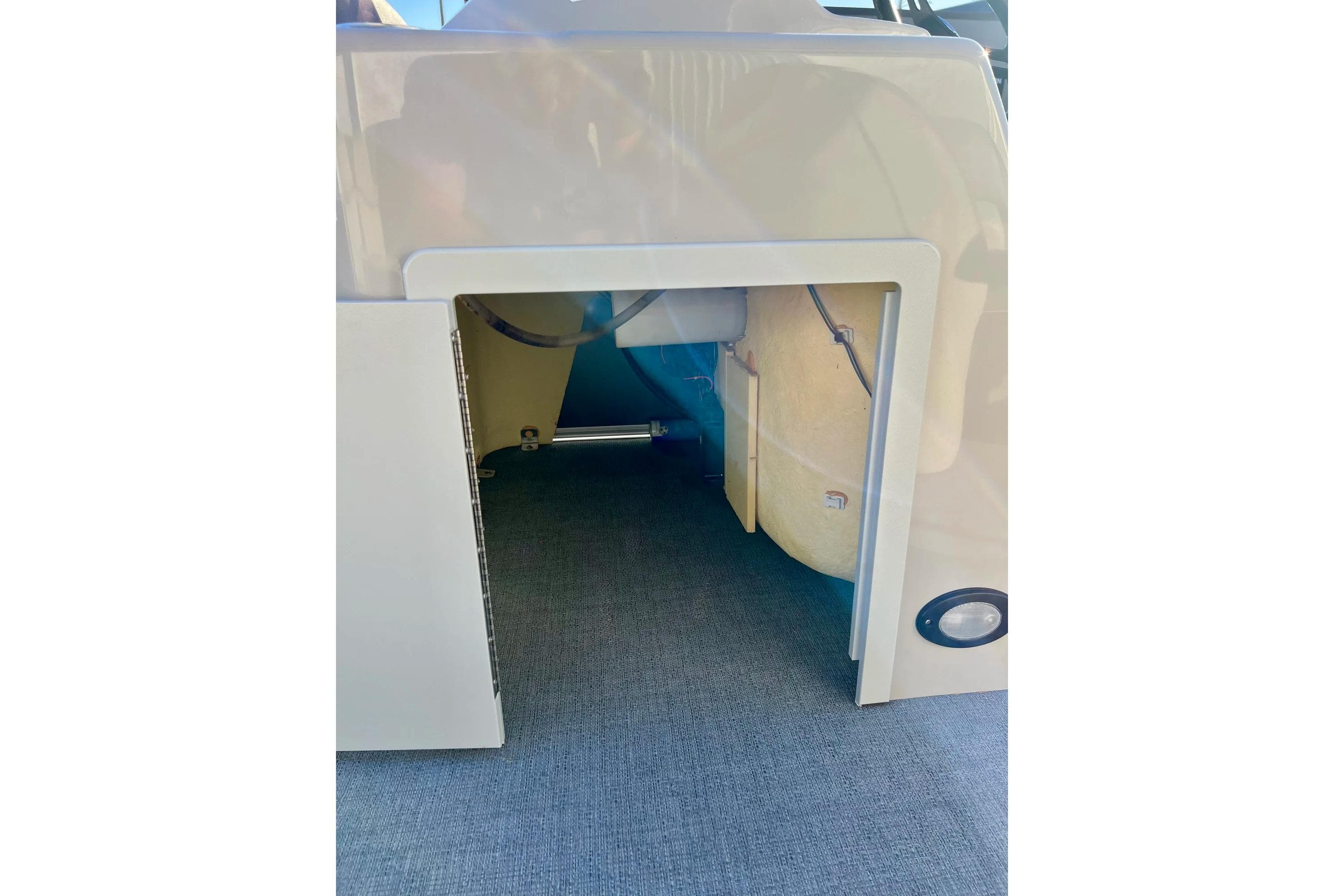 2021 SMOKERCRAFT EX20C boat storage compartment with open hatch, revealing interior details.
