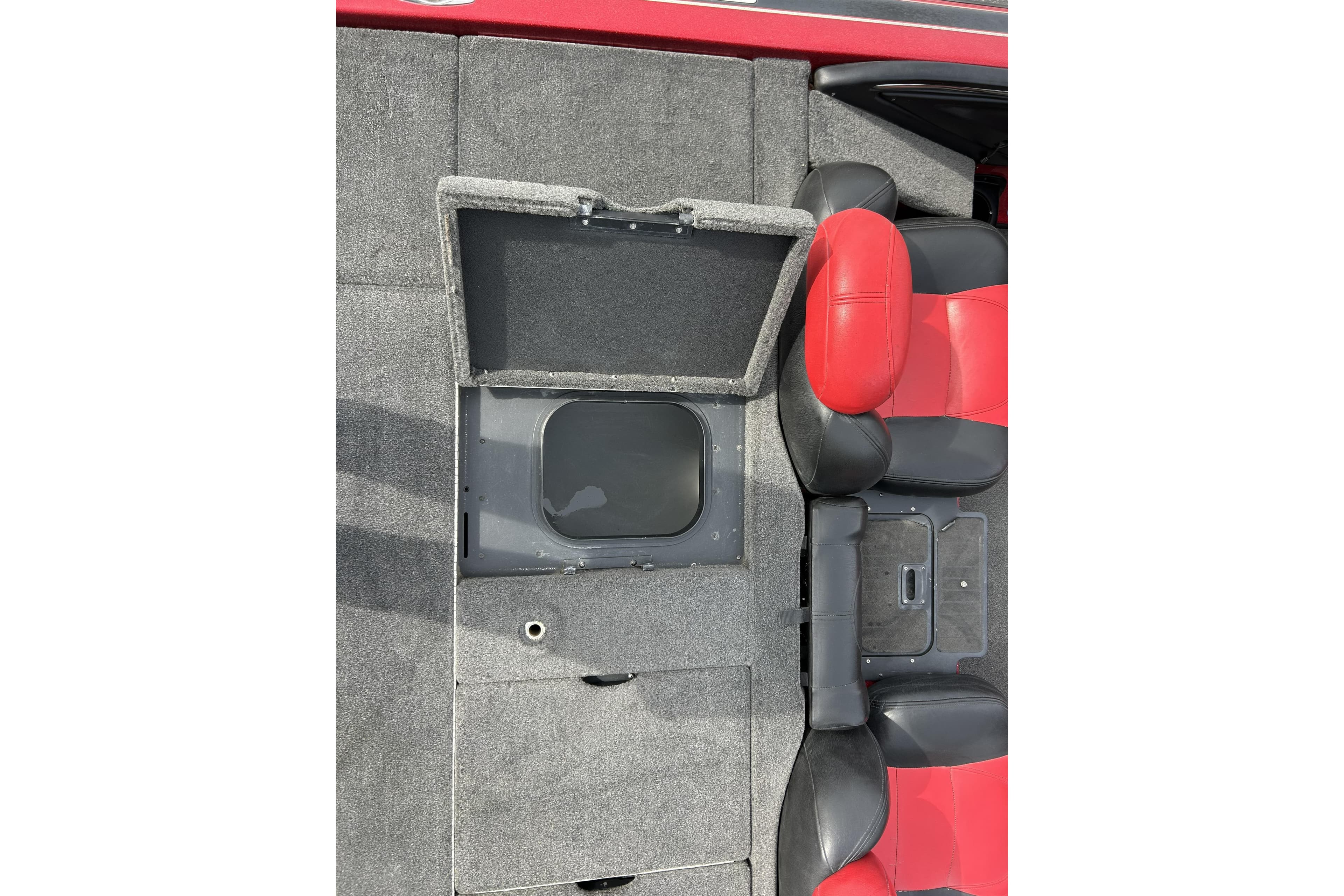 2007 Skeeter 20i boat interior with open storage compartment and red-black seats.
