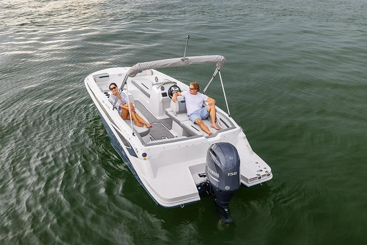 2022 Hurricane SunDeck Sport 205 OB boat cruising on open water with two passengers.