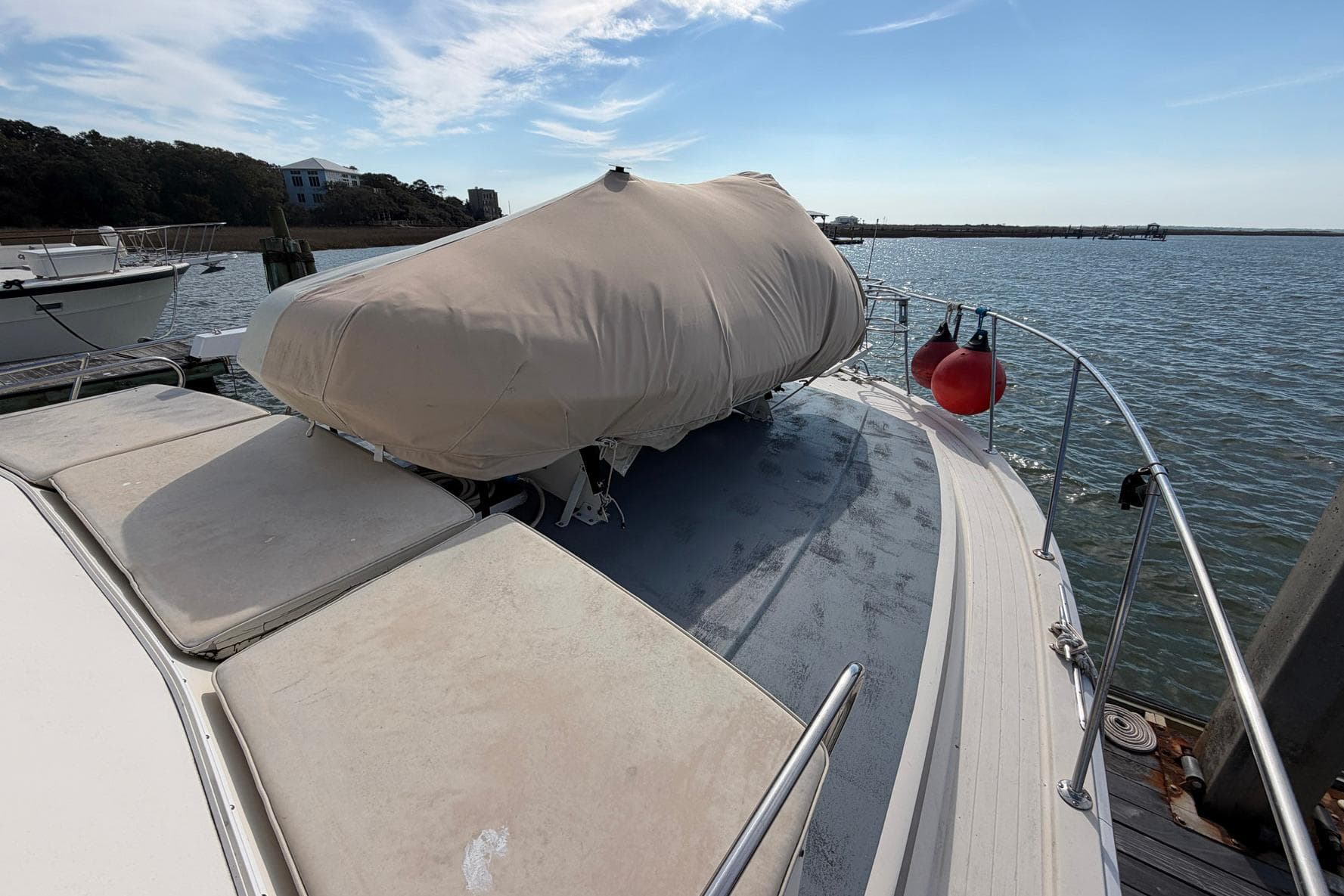 1987 Viking 44 Motor Yacht docked, covered, with scenic water and sky backdrop.