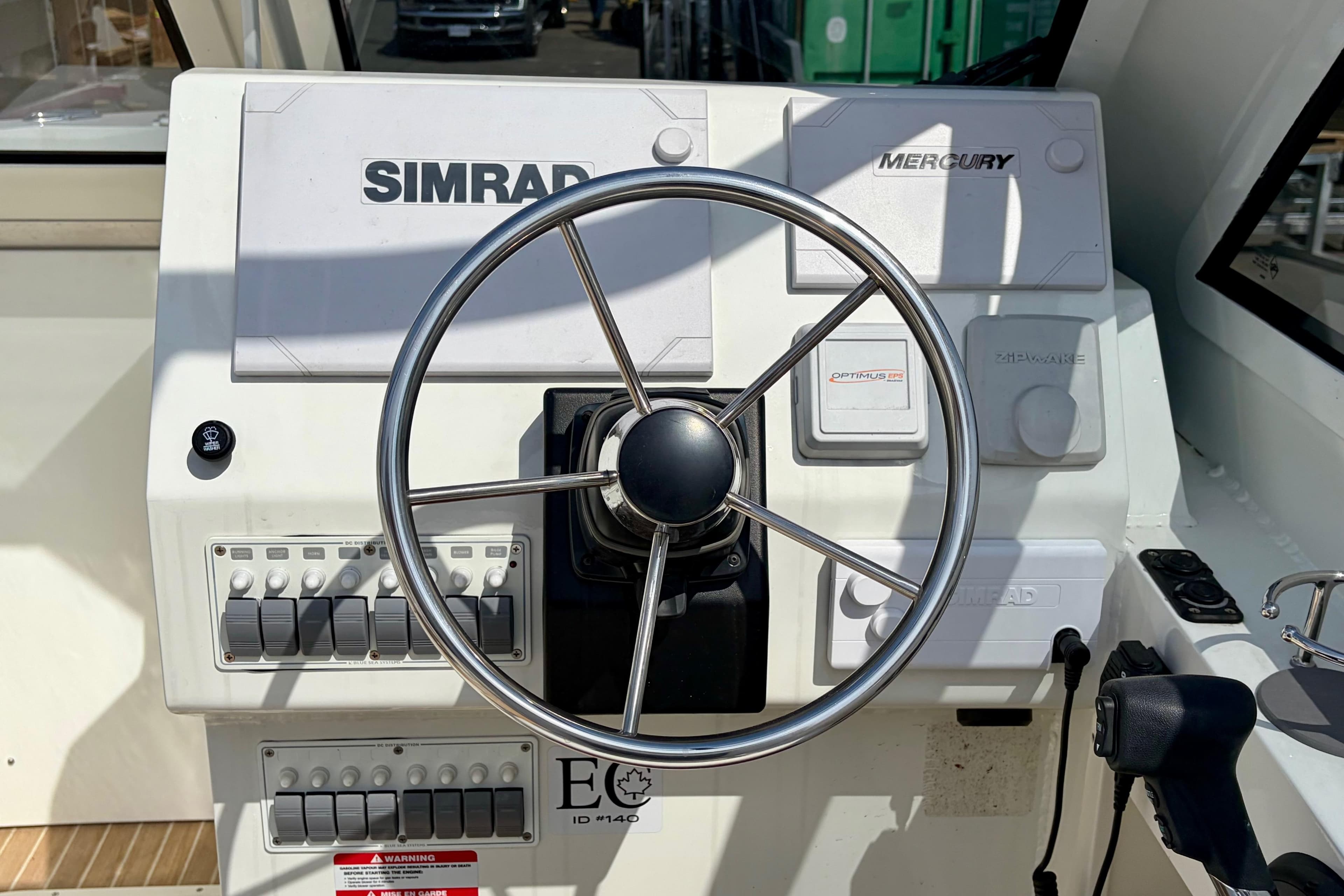 Steering console of 2024 Liquid Metal Marine 23 Quatsino boat with Simrad and Mercury controls.