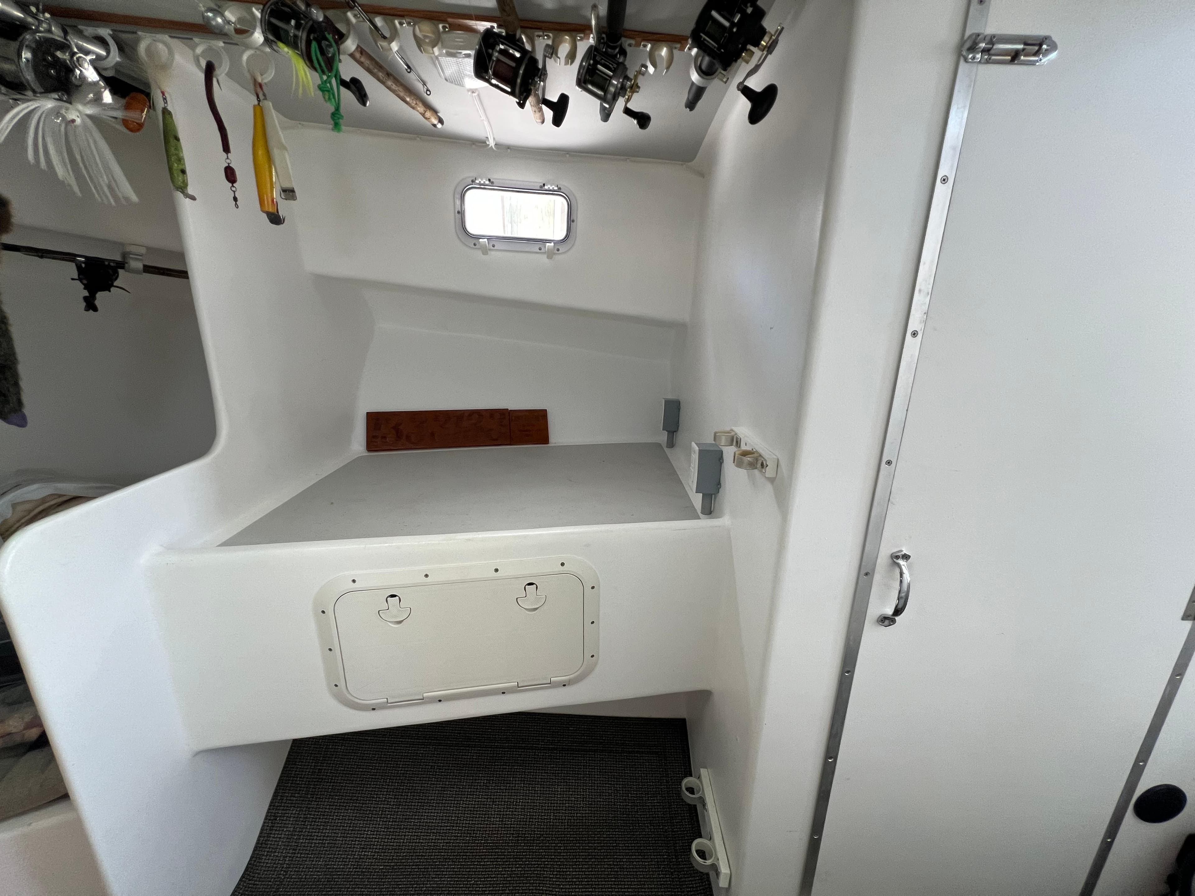 Interior of 2022 Wesmac 38 boat with fishing rods and storage area.