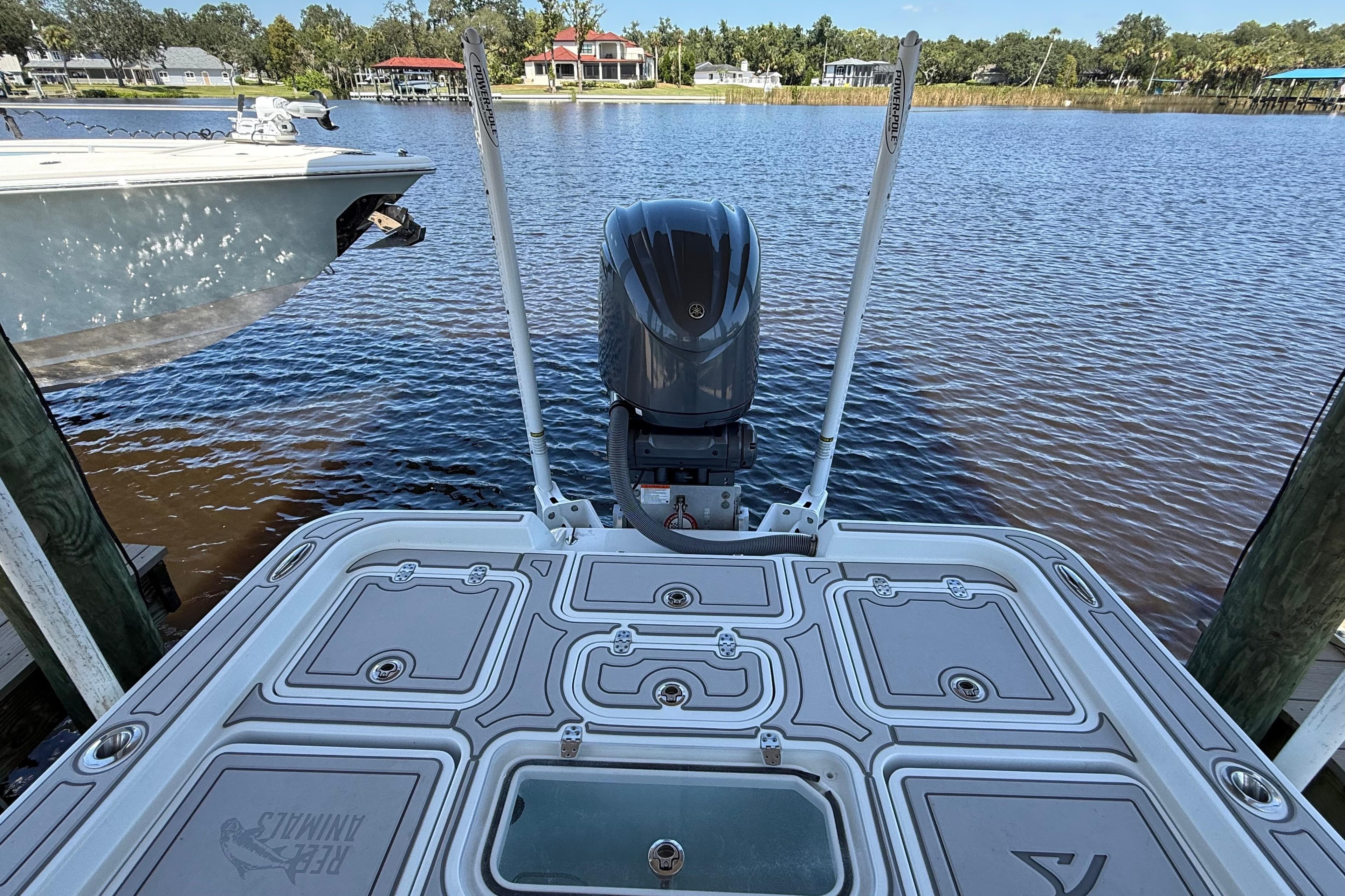 2024 Contender 26 Bay boat docked by a serene waterfront, showcasing its sleek design.