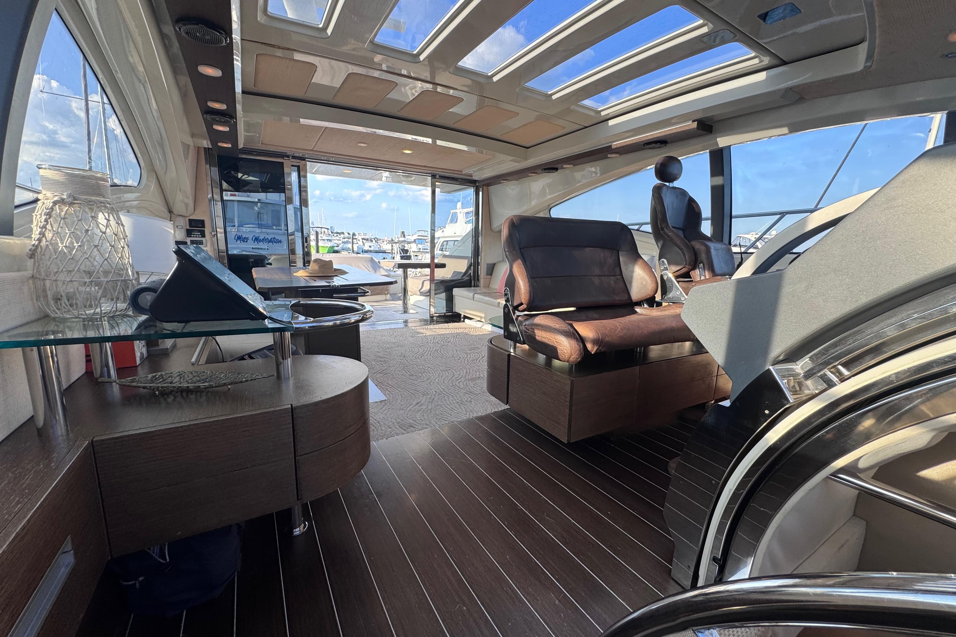 Luxurious interior of 2006 Azimut 68S yacht with modern seating and panoramic windows.