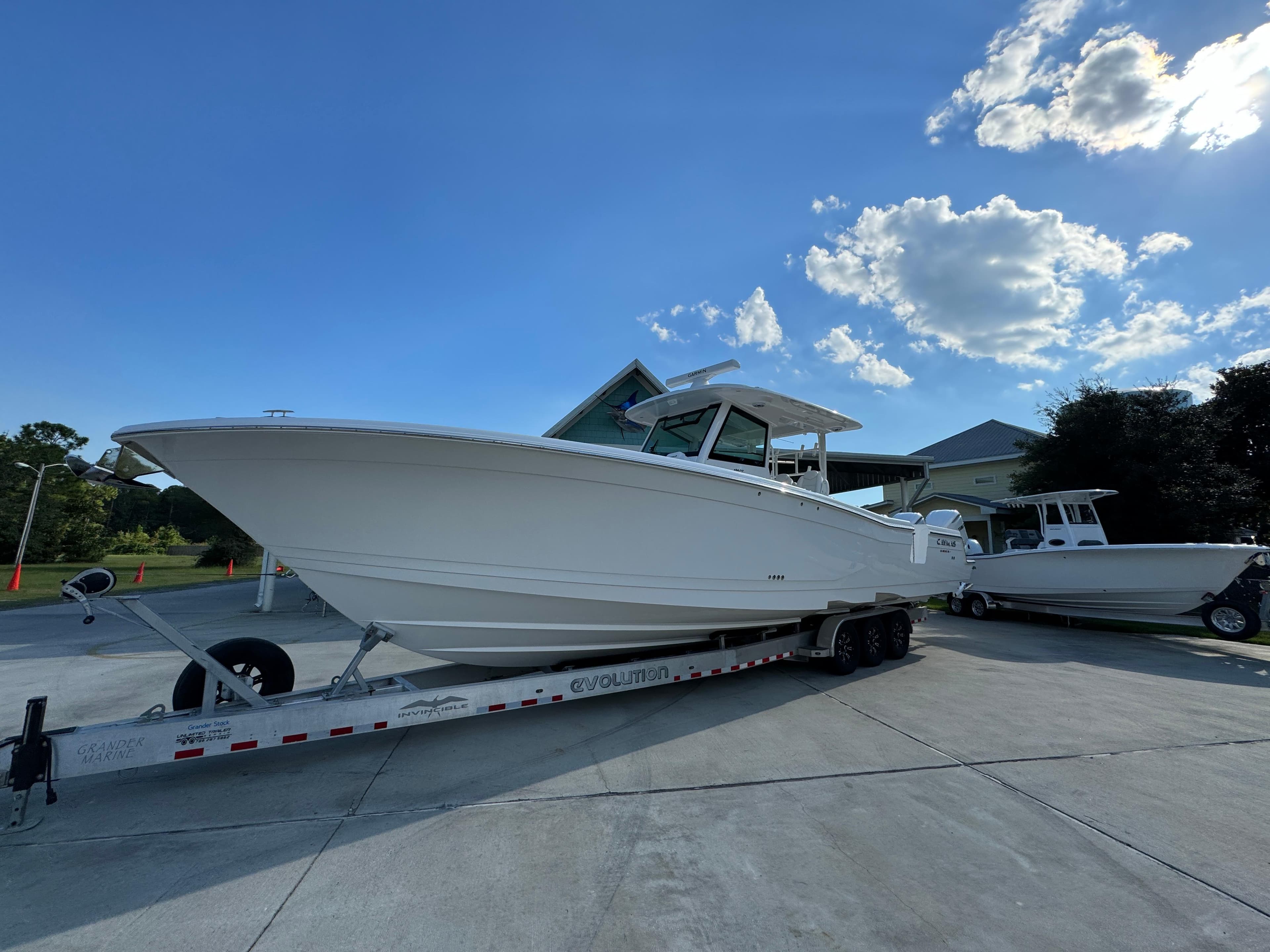 2025 Caymas 401 CC boat on trailer under clear blue sky.