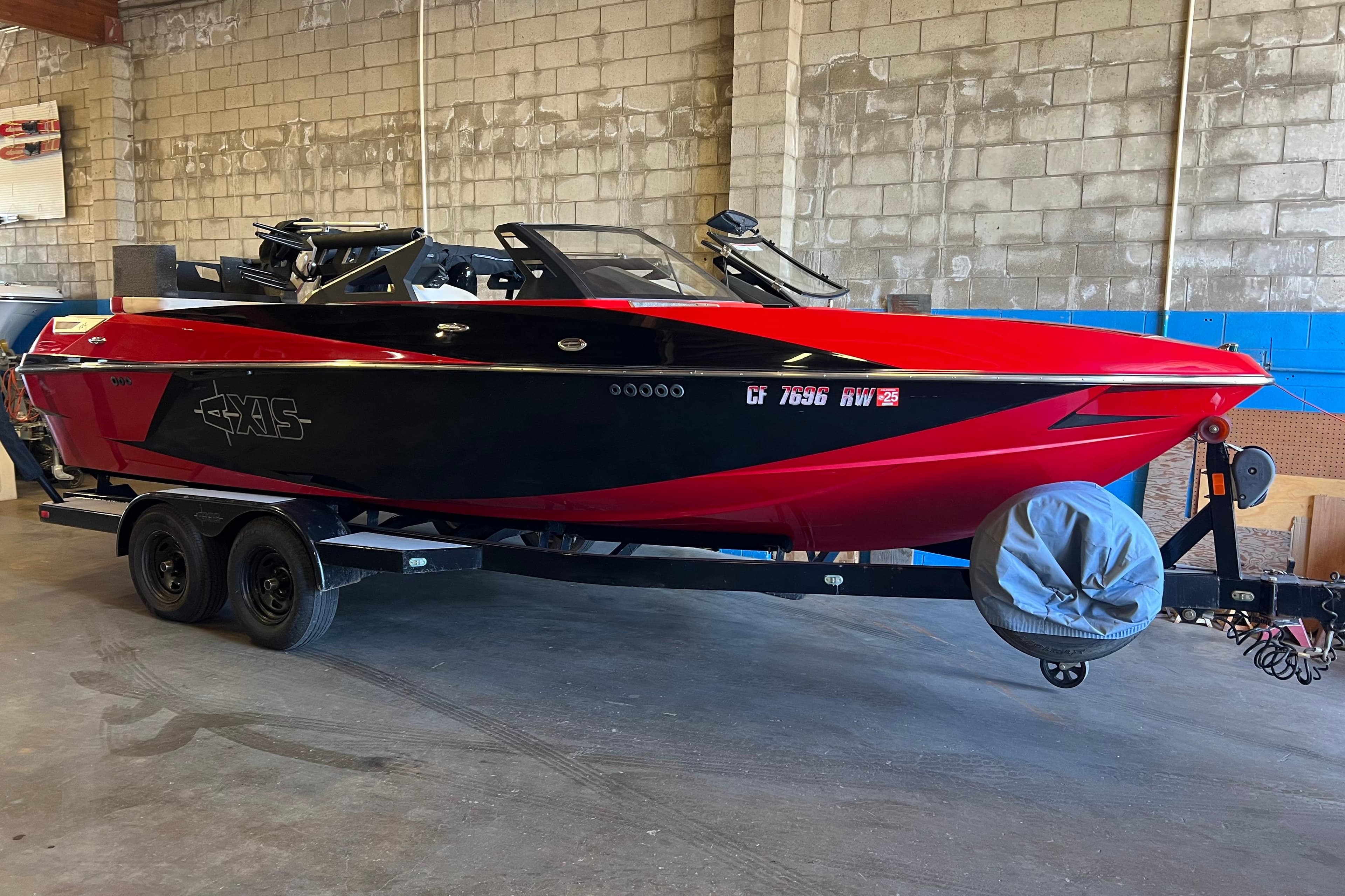 2016 Axis T22 boat in red and black on a trailer in a garage.