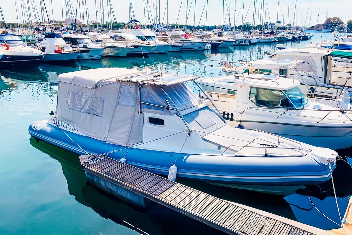 2016 Nautica Cab Silverado 9 boat docked in a marina with other vessels.