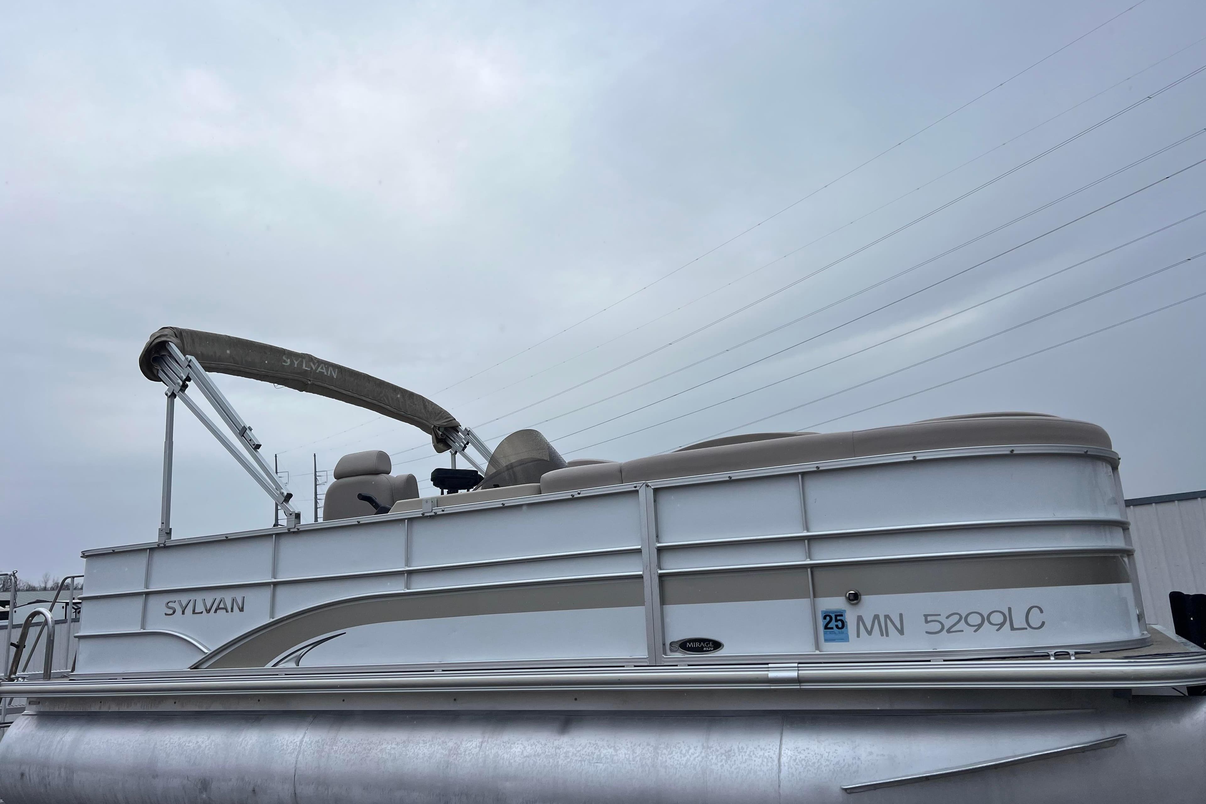 2014 Sylvan Mirage Cruise 8520 CR pontoon boat with beige canopy and seating.