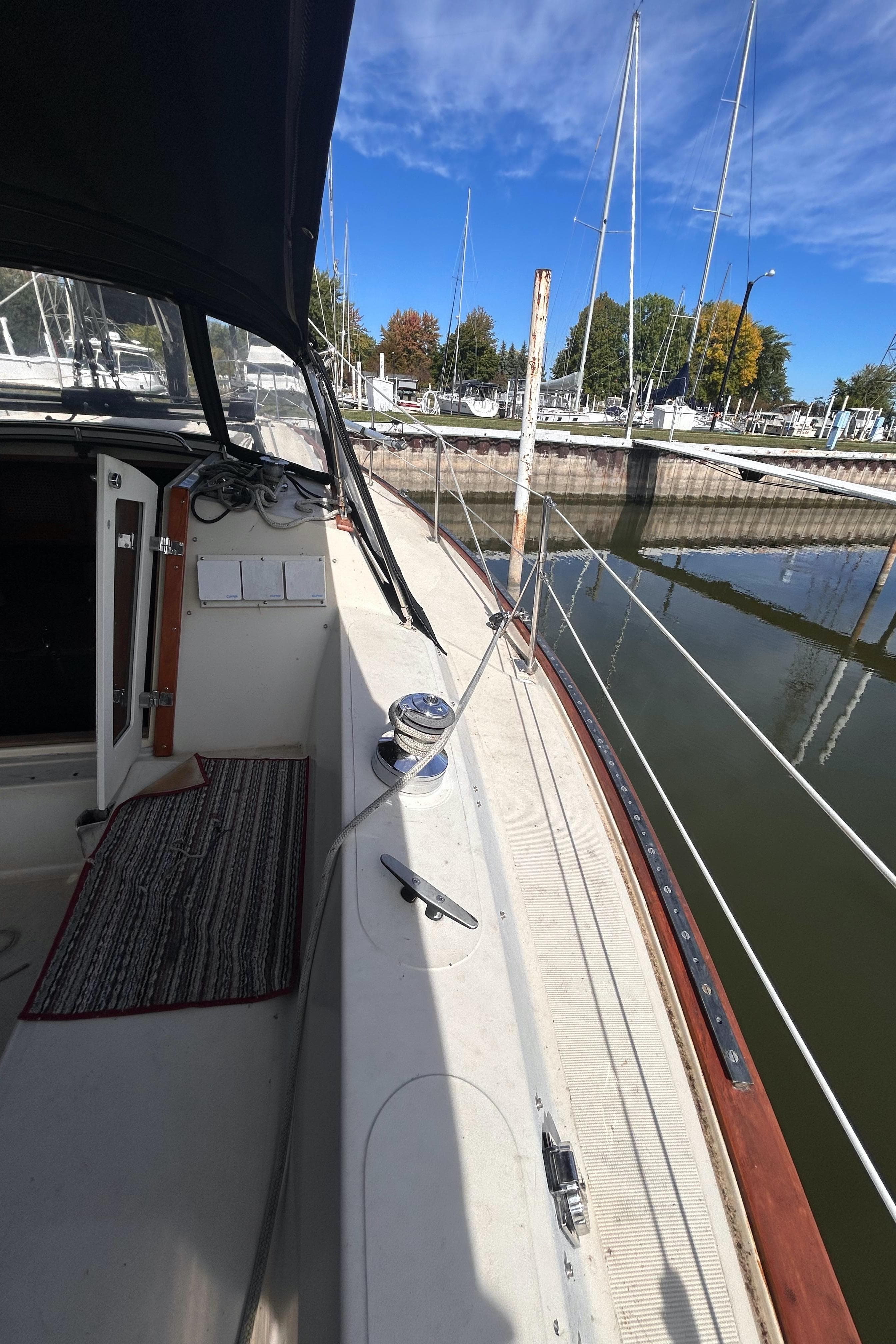 1982 S2 11.0 A sailboat docked at marina, clear sky, calm water.