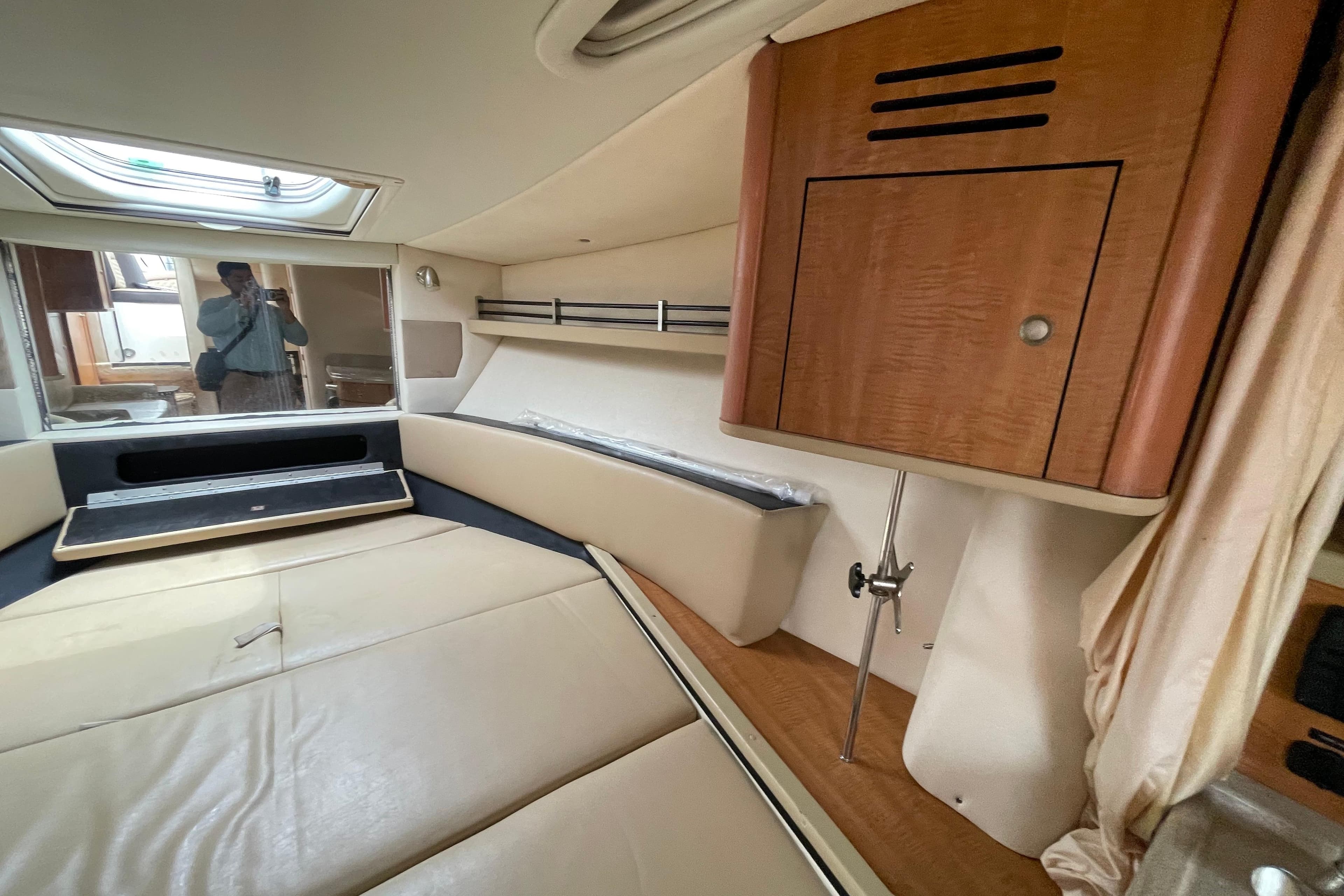Interior cabin of 2006 Sea Ray 290 Sundancer with beige seating and wooden cabinetry.