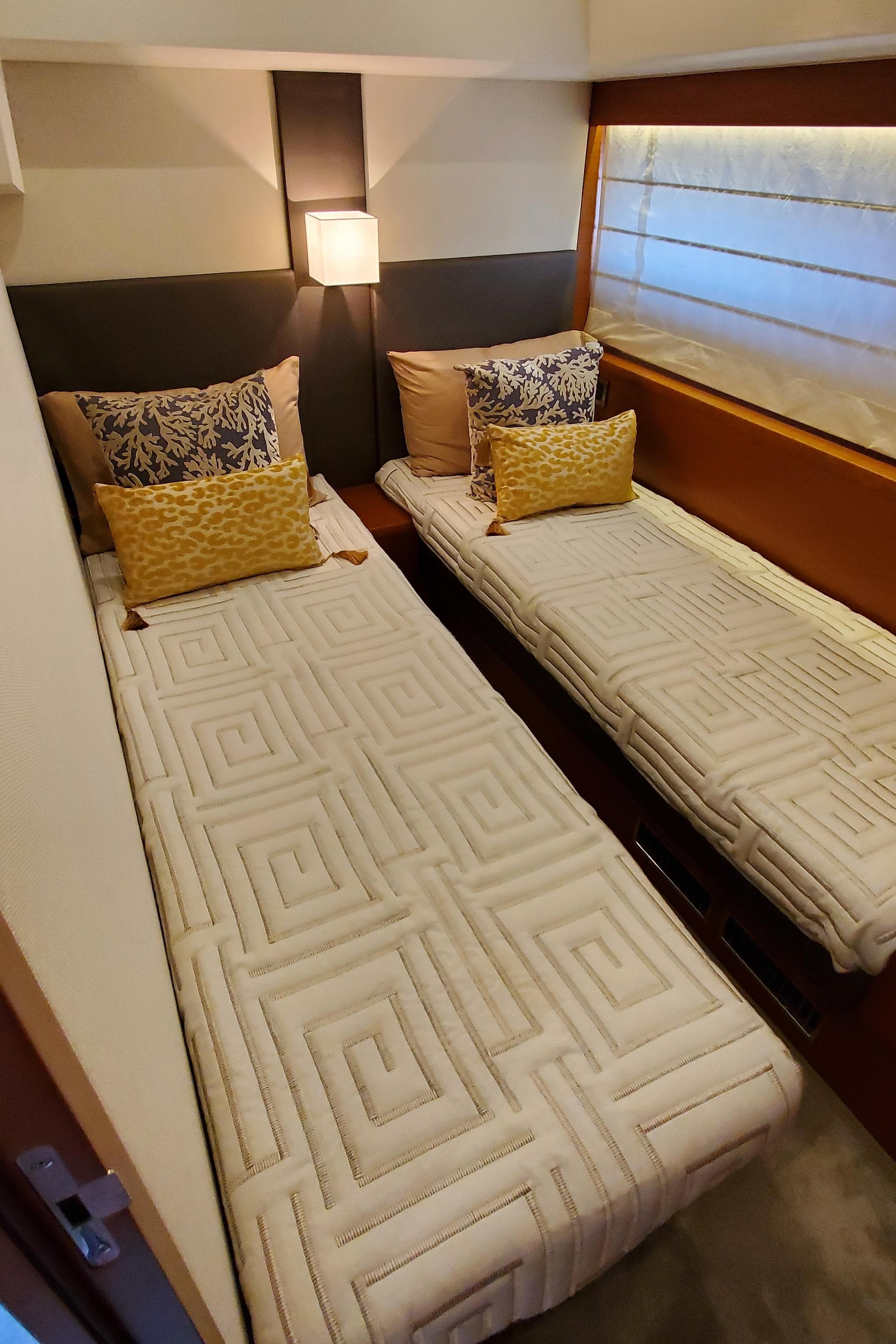 Twin beds in a 2017 Prestige 560 Flybridge yacht cabin, featuring elegant bedding and decor.
