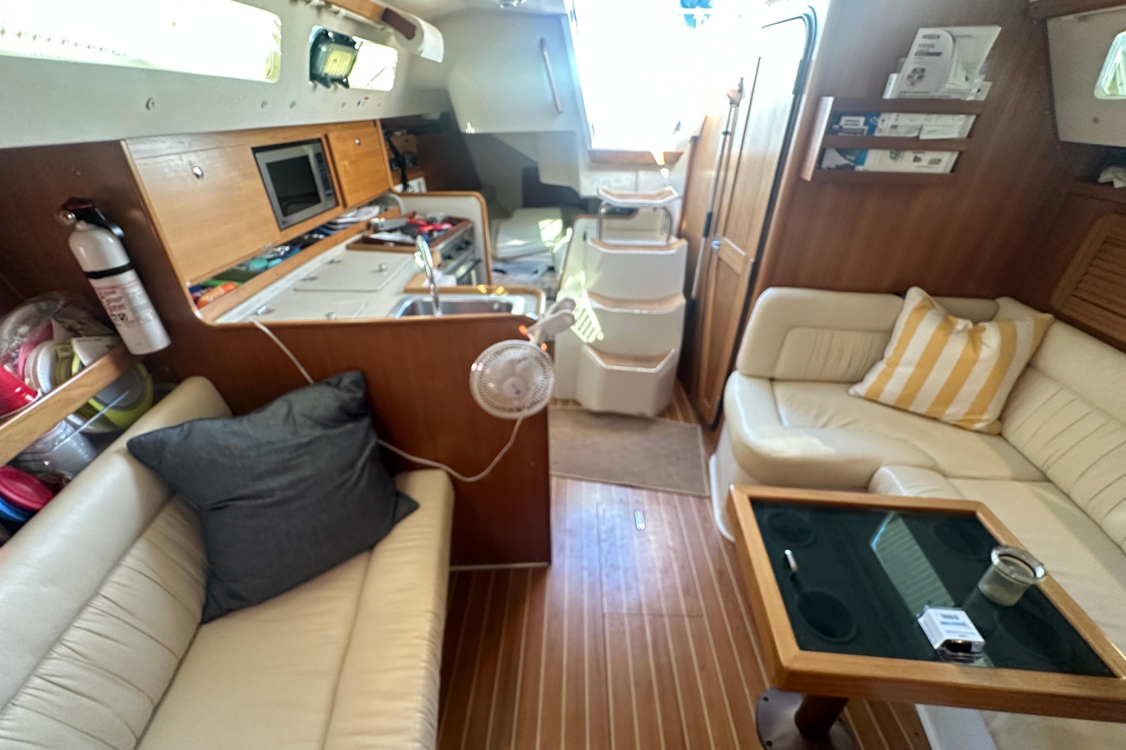 Interior of a 2005 Catalina 310 sailboat with cozy seating and wooden finishes.