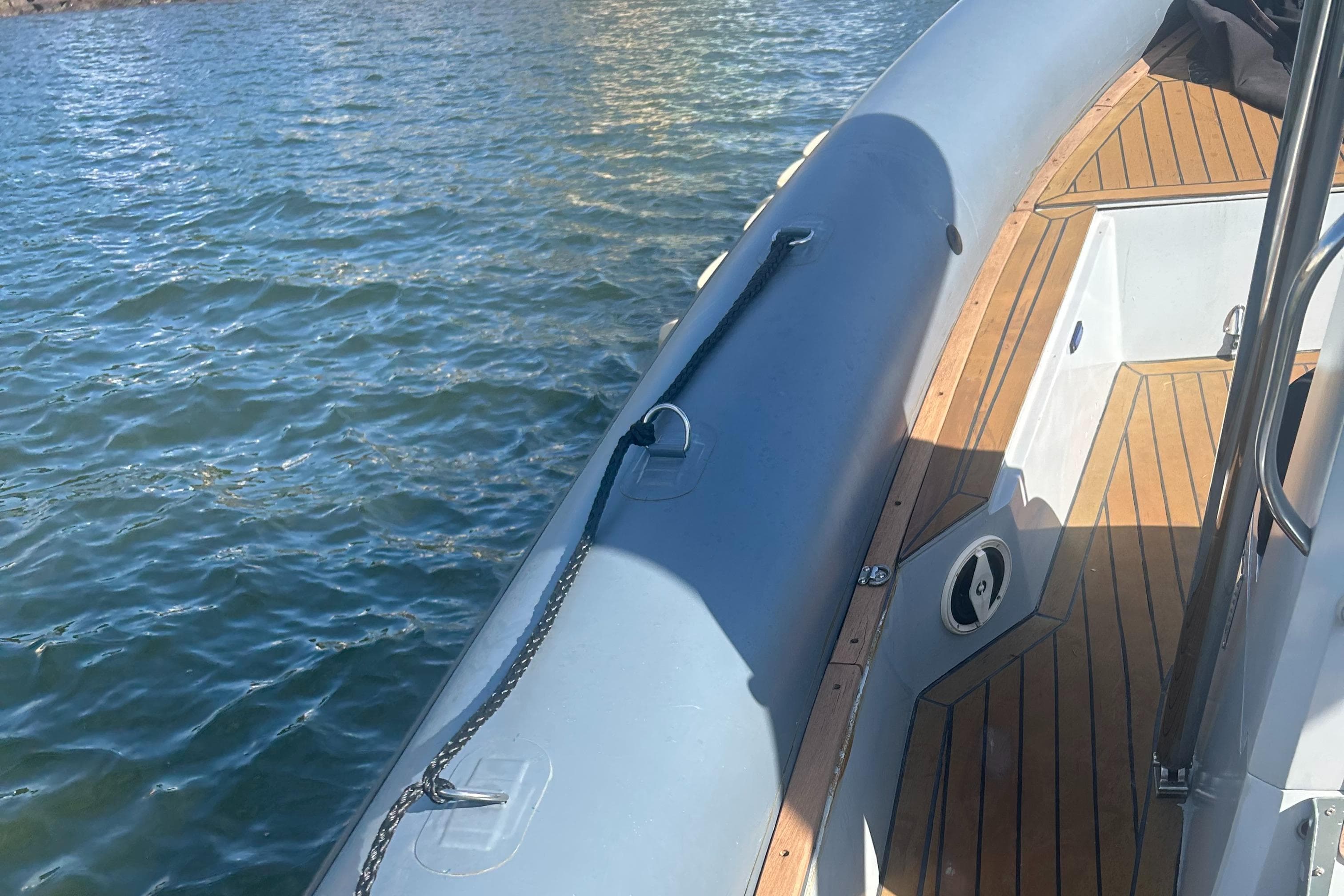 2008 RIB U-23 Carbon Hull boat on water, featuring wooden deck and sleek design.