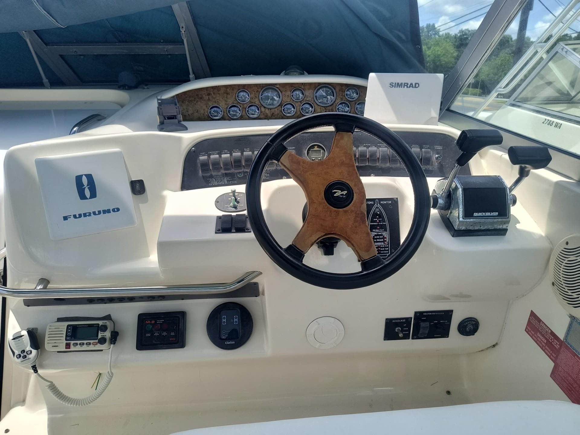 1995 Sea Ray 330 Sundancer helm with steering wheel, gauges, and navigation equipment.