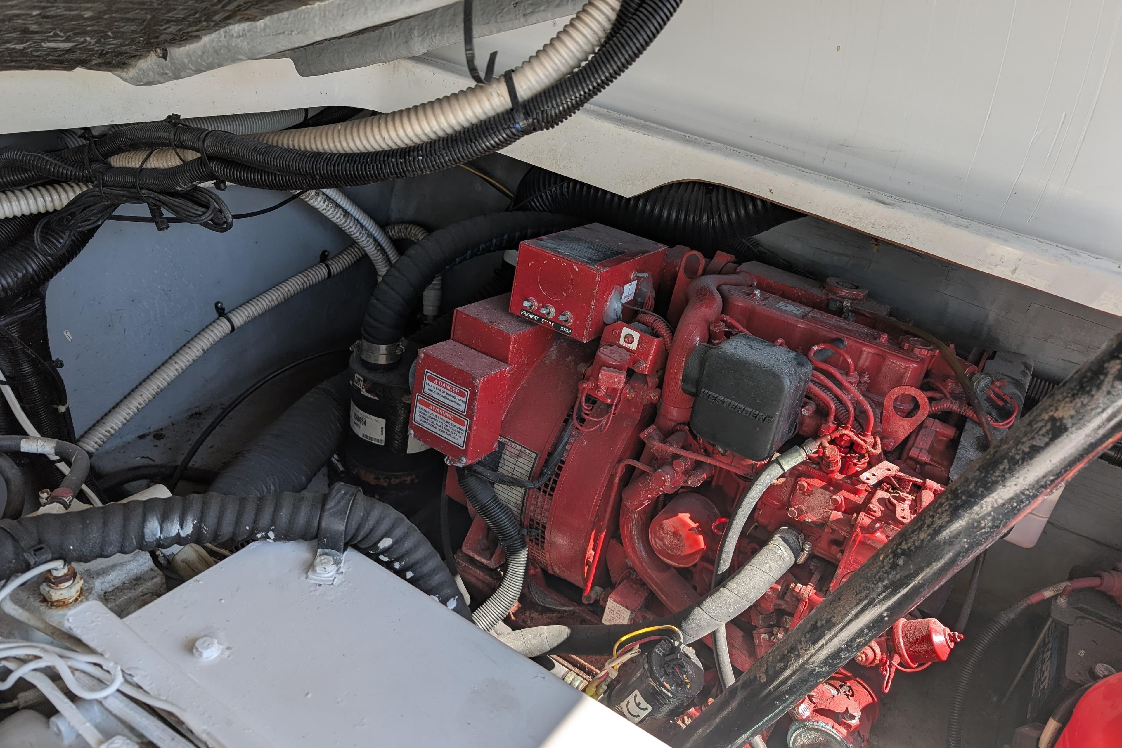 Engine compartment of a 1999 Sea Ray 370 Express Cruiser with red engine components.