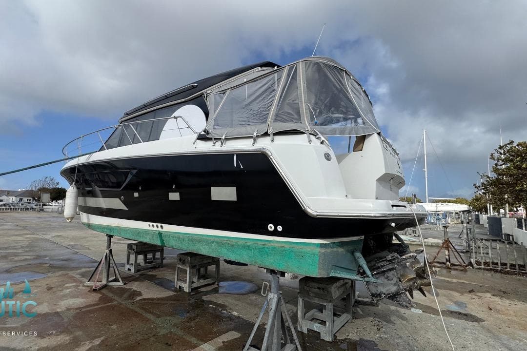 2013 Jeanneau NC 11 boat on dry dock, black and white exterior, covered cockpit.