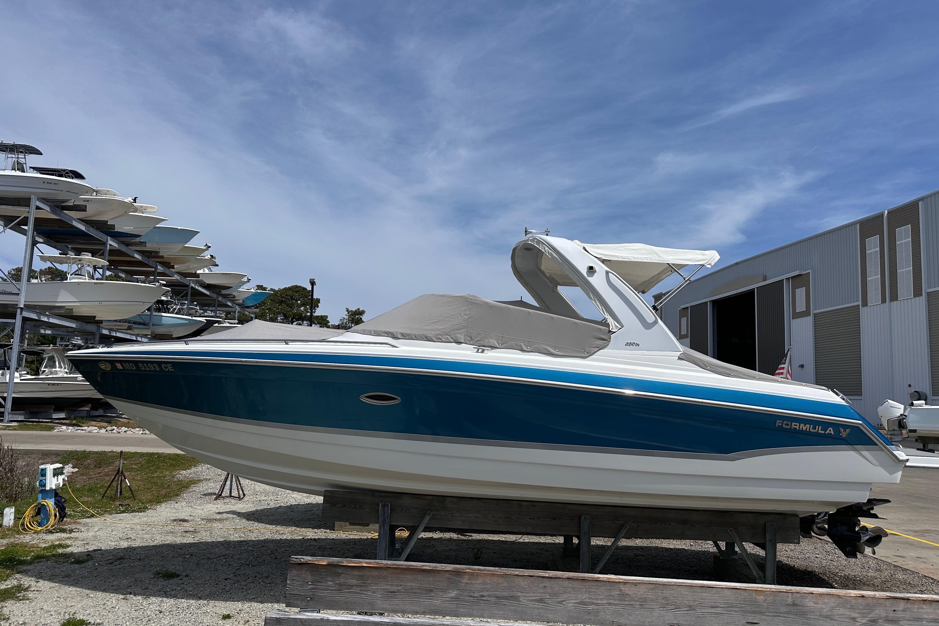2006 Formula 280 Bowrider boat on dry dock, blue and white exterior, sunny day.
