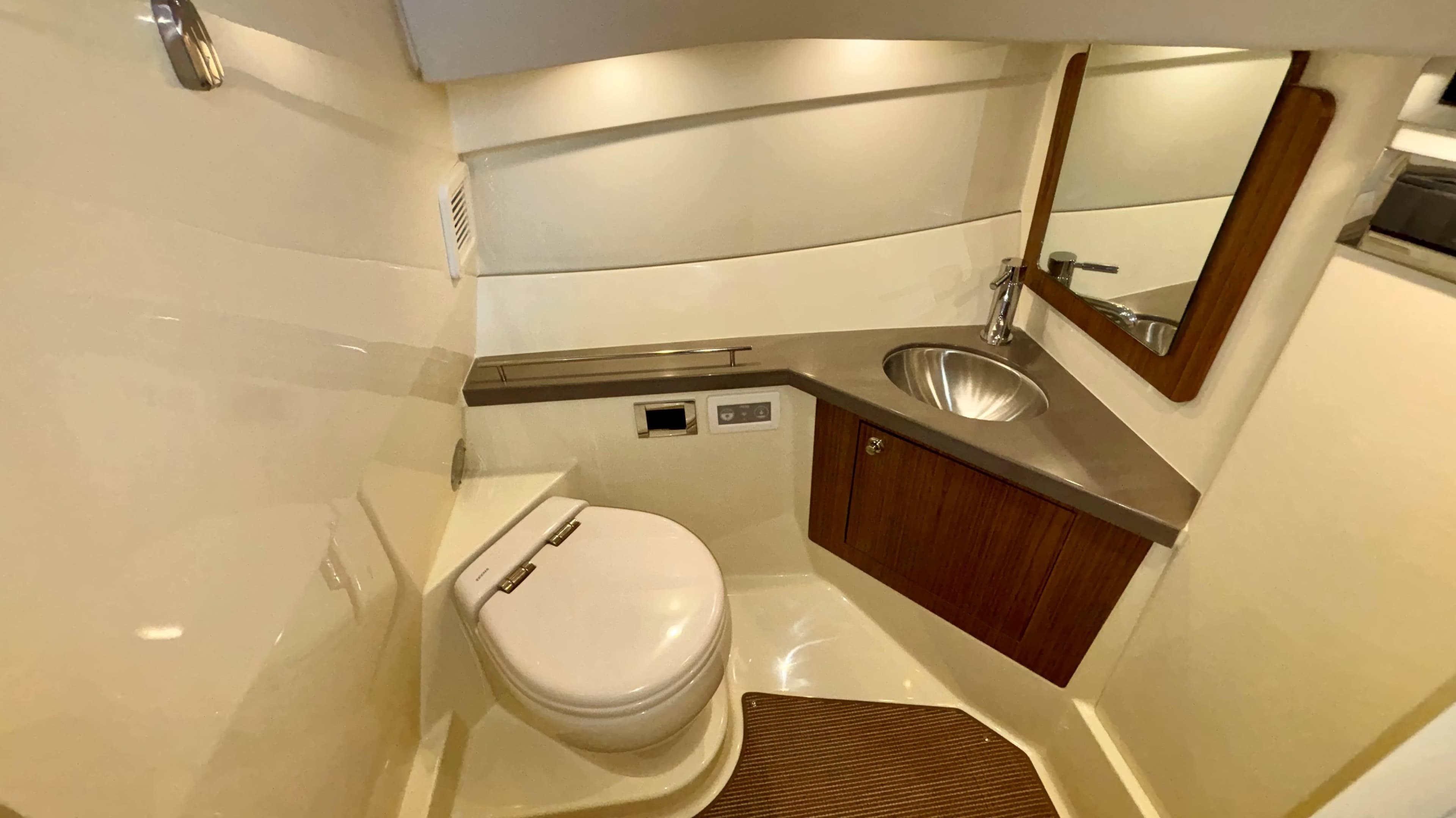 2024 Chris-Craft Calypso 32 CT boat bathroom with modern fixtures and wooden accents.