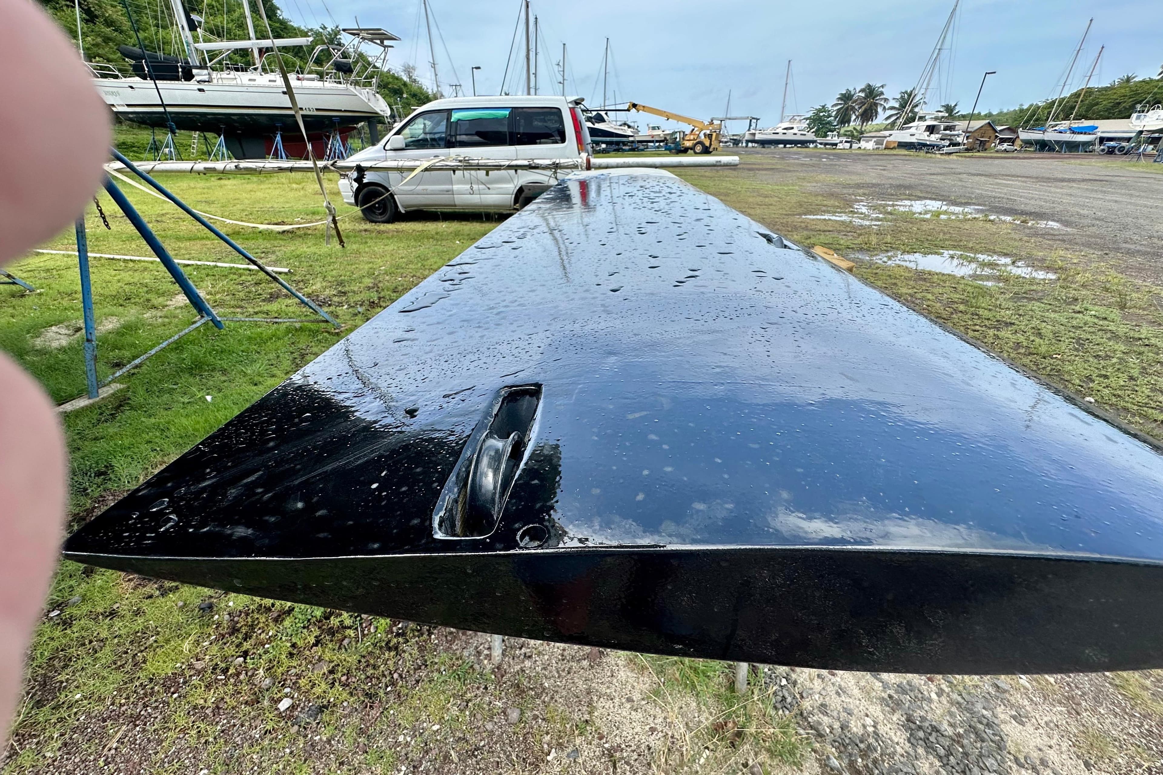 A wet, black boat keel from an Alibi 54, 2011, in a shipyard setting.