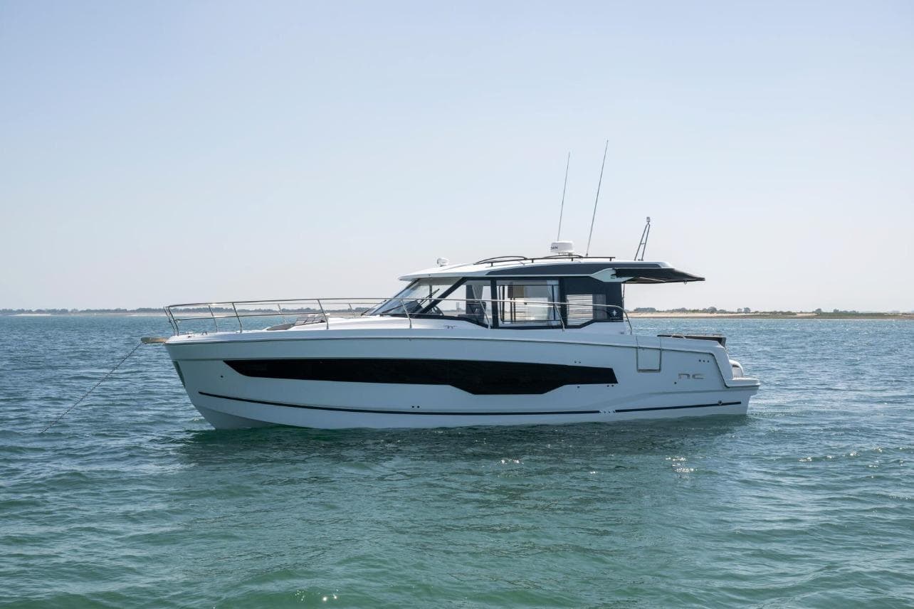 2026 Jeanneau NC 1295 Weekender yacht on calm waters, side view.