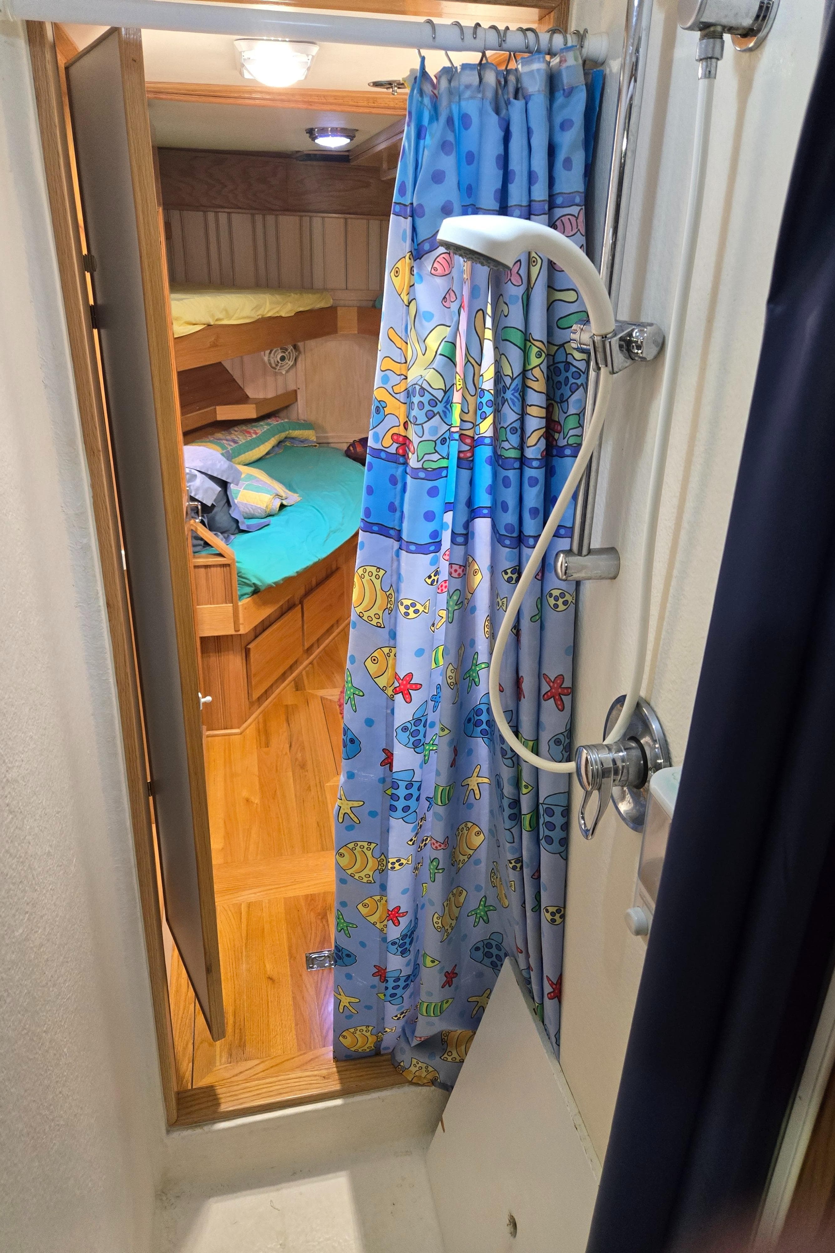 Compact shower area in 2000 Expedition custom vehicle with colorful curtain and cozy interior.