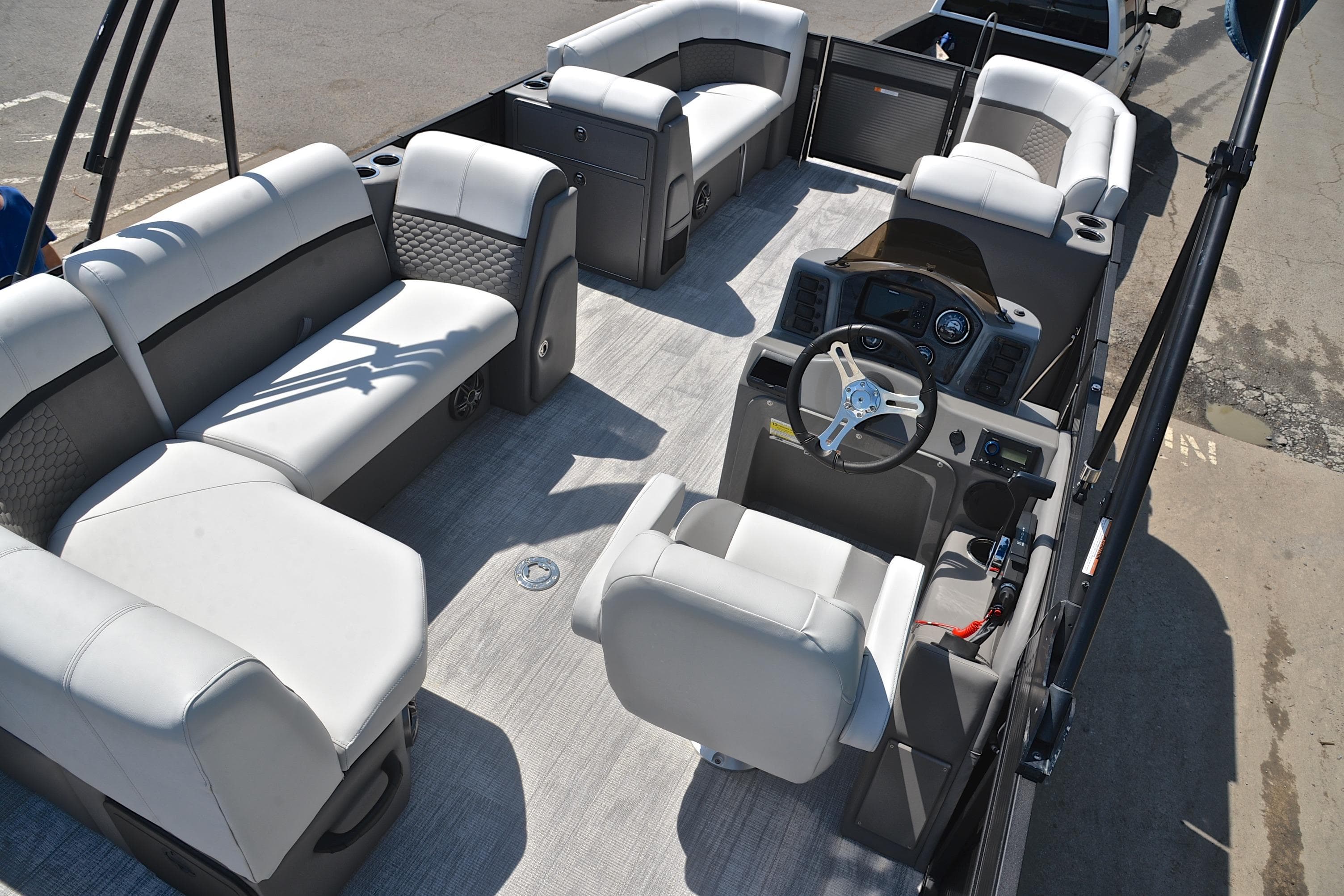 Luxurious interior of 2022 Qwest E822 pontoon boat with plush seating and modern helm.