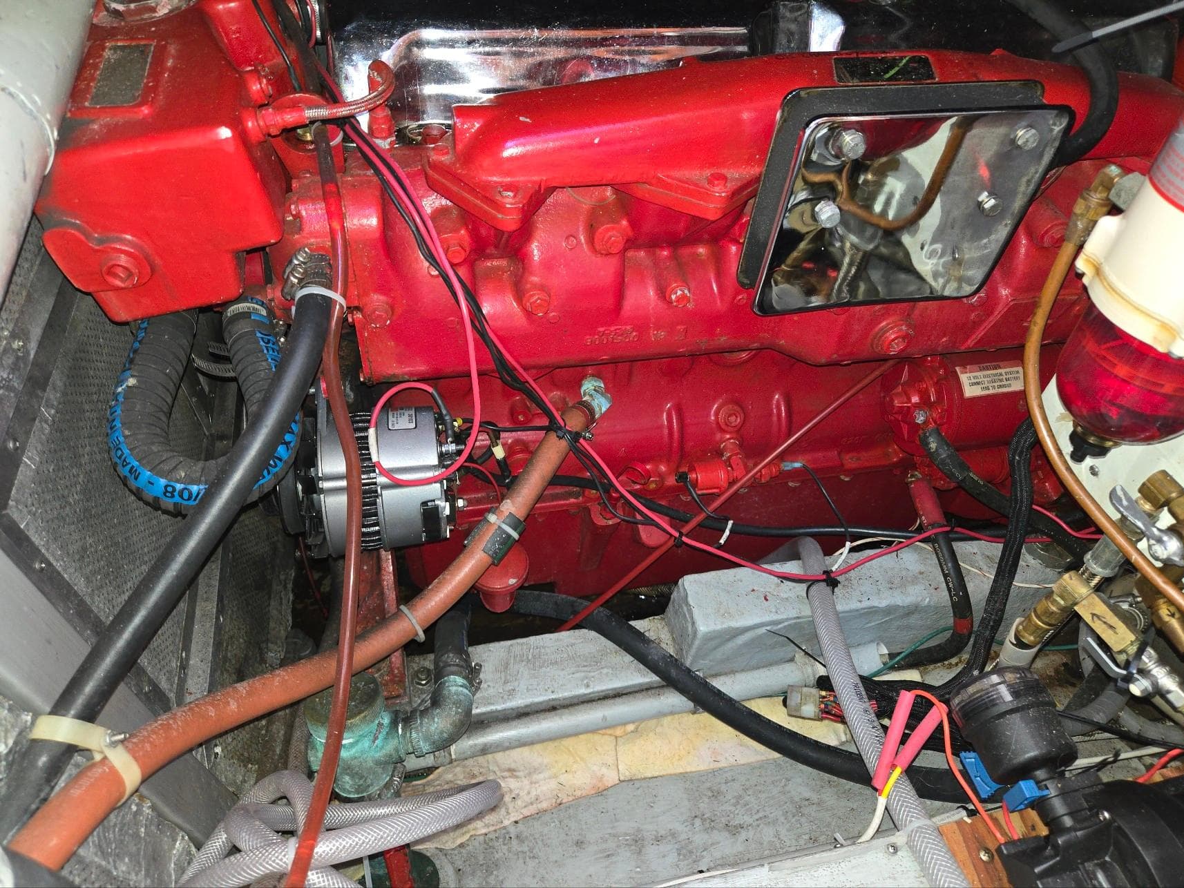 Engine compartment of a 1989 Eagle Pilothouse with red components and wiring.