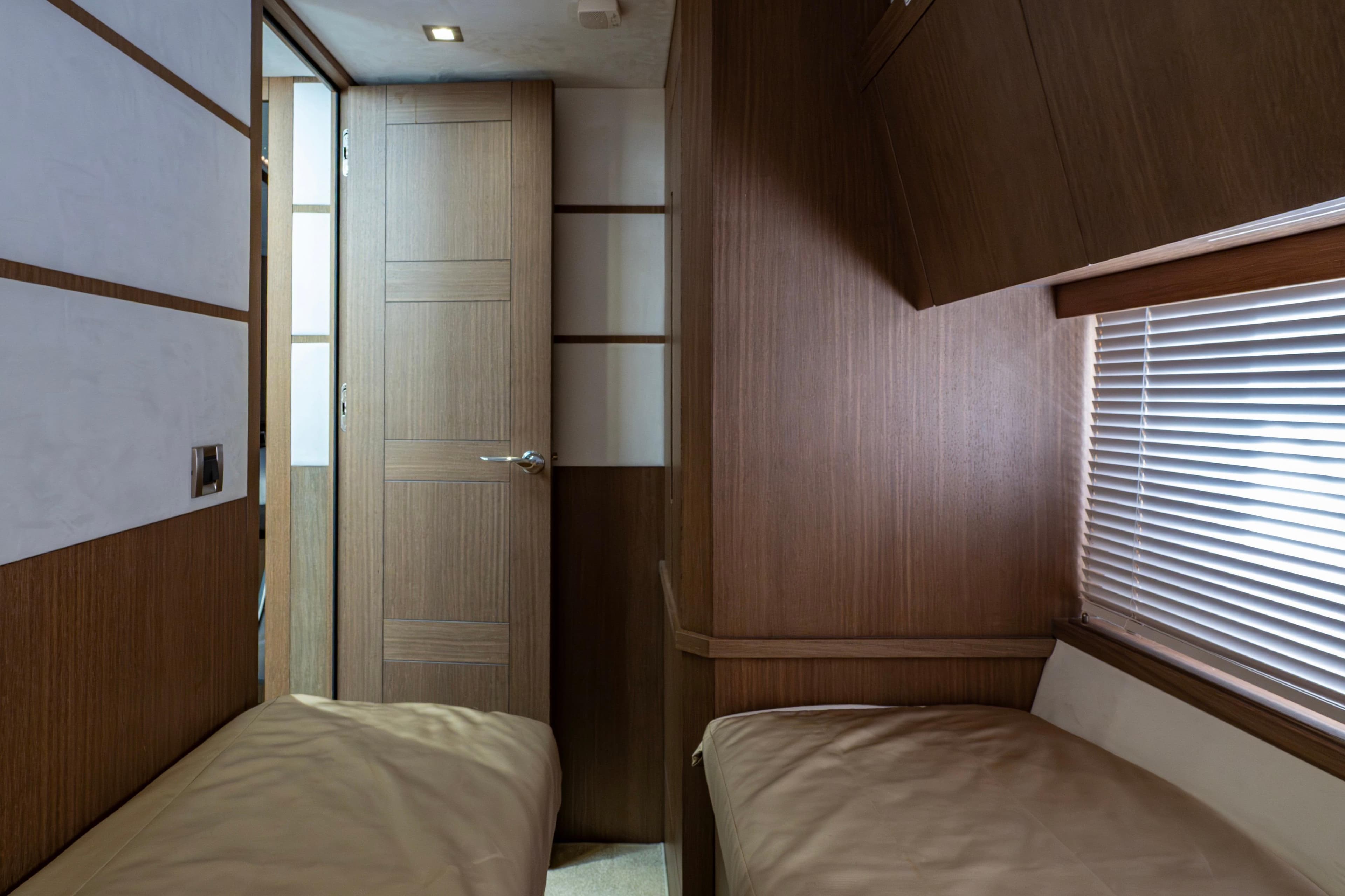 Interior of 2020 Galeon 550 Fly yacht cabin with twin beds and wooden decor.